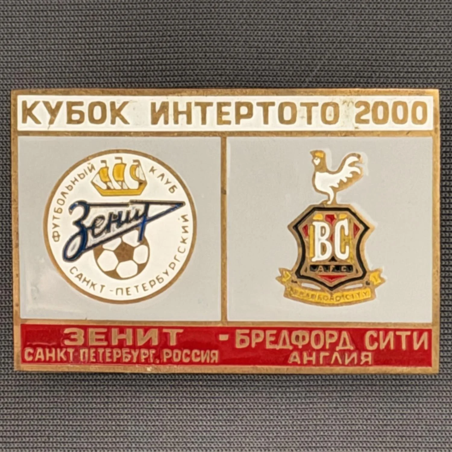 Reference Number: BCRUS017
Size: H 29.6 mm x W 44.6 mm
Pin Type: Metal Clutch
Plating: Antique Gold
Value: £12
Manufacturer: Unknown
Comments: Zenit St. Petersburg Inter Toto Cup, White Top, Grey Middle, Red Bottom