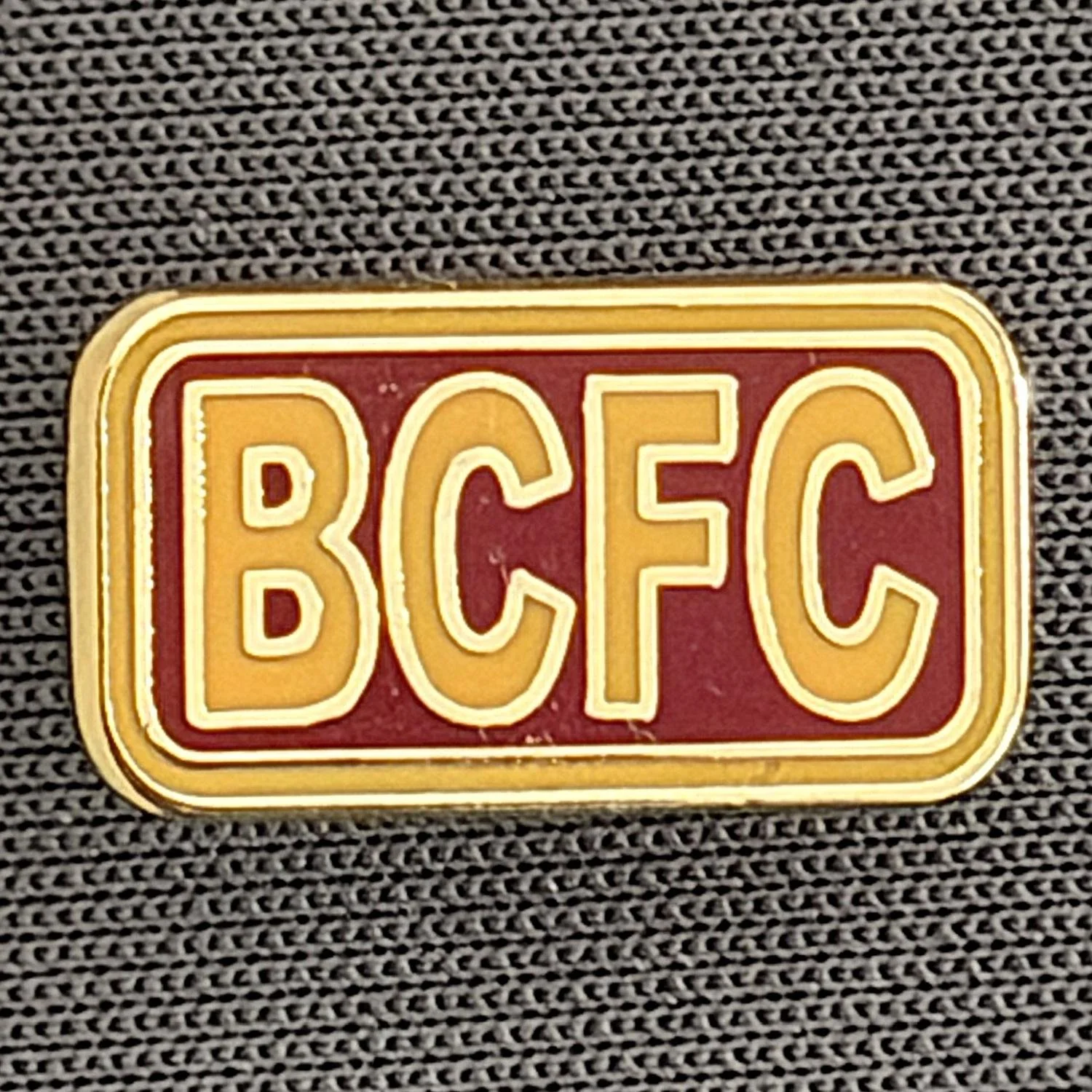 Reference Number: BCBCFC073
Size: H 8.5 mm x W 15.5 mm
Pin Type: Metal Clutch
Plating: Gold
Value: £4
Manufacturer: Unknown
Comments: BCFC Amber & Claret Version