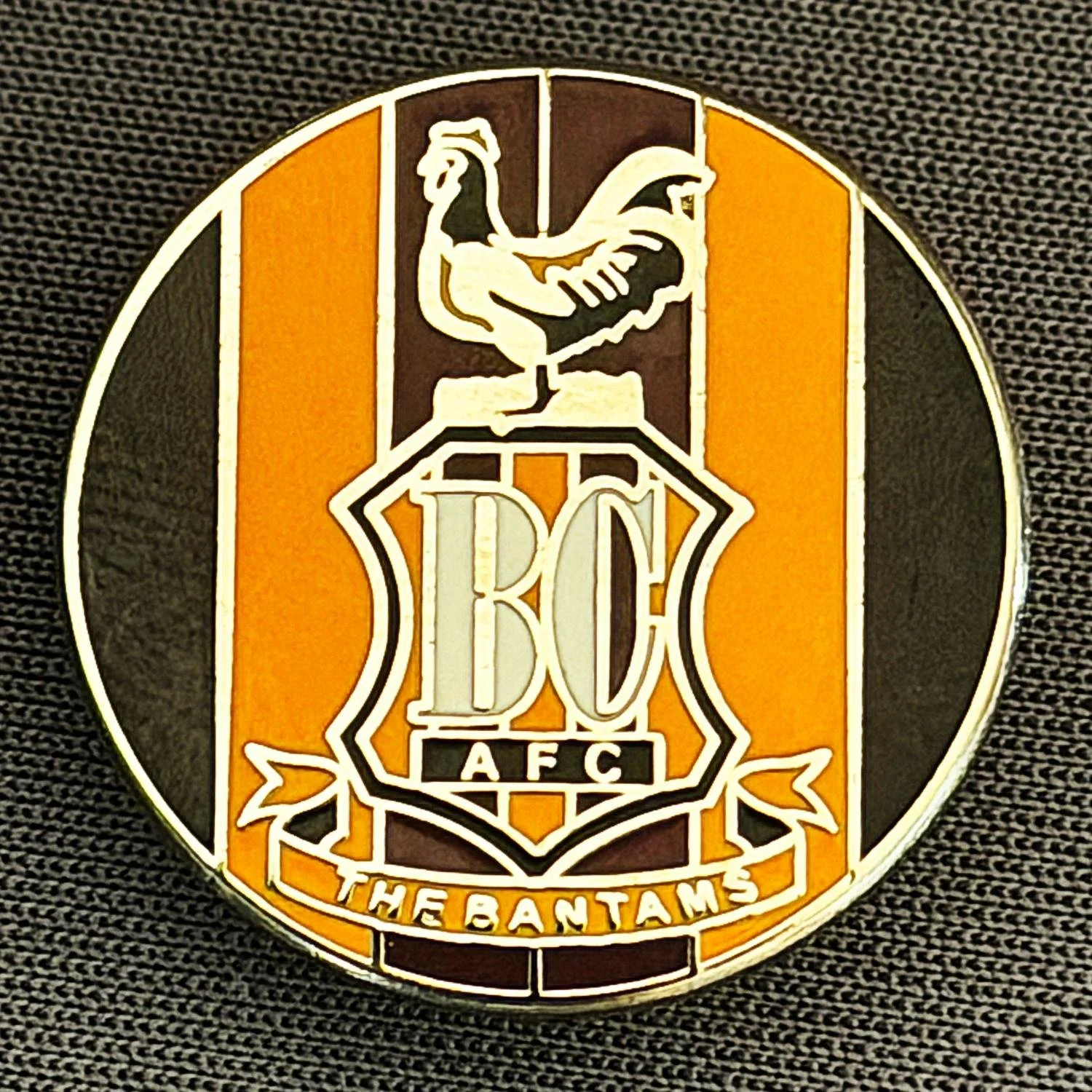 Reference Number: BCC&L119
Size: D 22.3 mm
Pin Type: Brooch Pin
Plating: Silver
Value: £6
Manufacturer: Unknown
Comments: Circular Claret, Amber & Black Stripes, City Crest