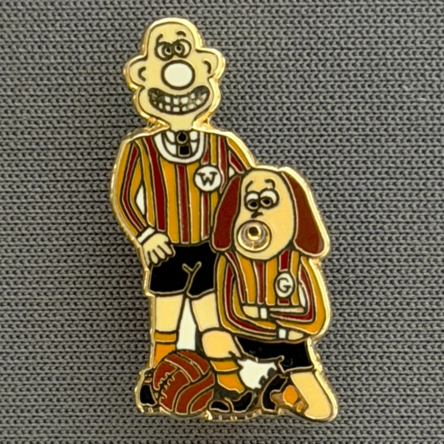 Reference Number: BCCTN033
Size: H 22.6 mm x W 11 mm
Pin Type: Brooch Pin
Plating: Gold
Value: £6
Manufacturer: Not Known
Comments: Wallace & Gromitt in Bradford City Kit Black Shorts