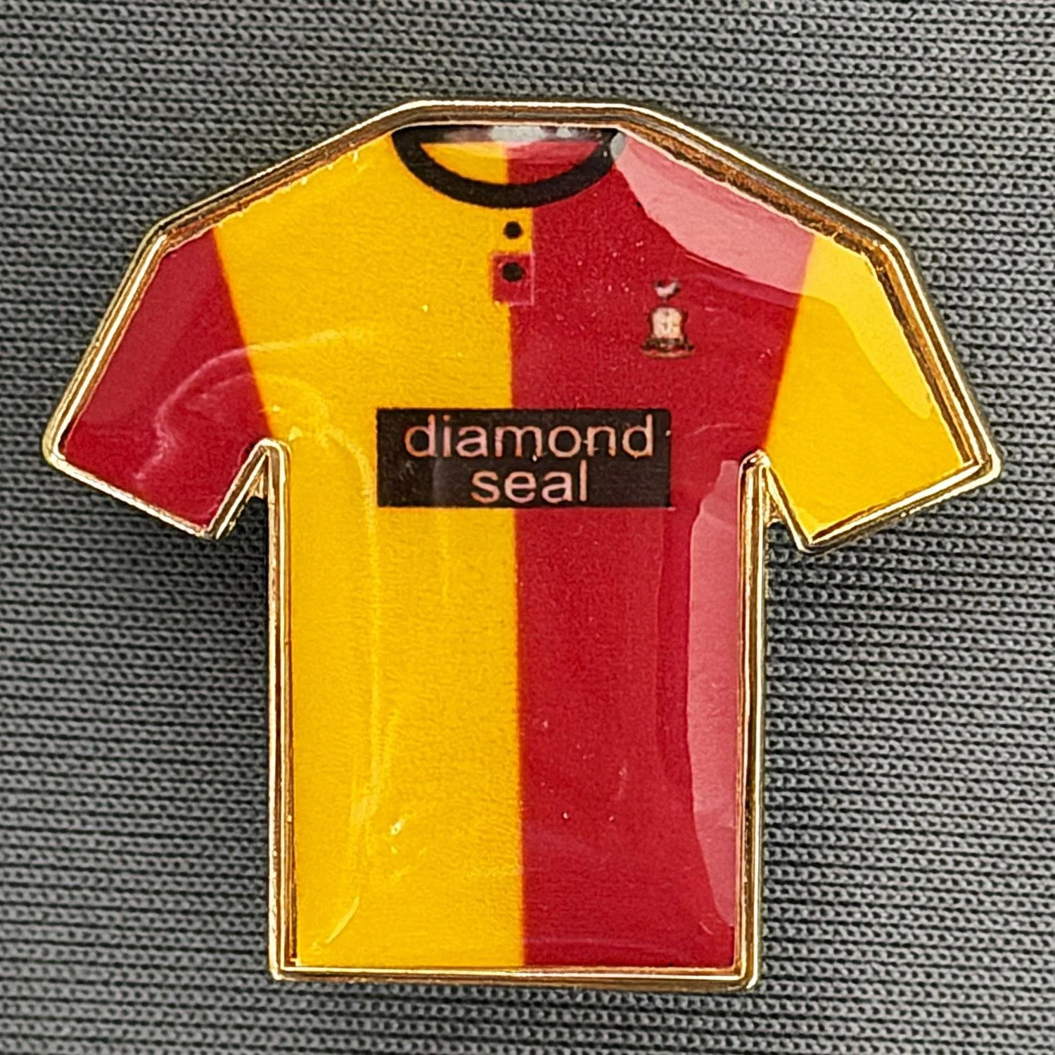 Reference Number: BCKIT013
Size: H 26.4 mm x W 28 mm
Pin Type: Brooch Pin
Plating: Gold
Value: £4
Manufacturer: Blue Badge Design
Comments: !996/97 Cup Kit, Plastic Dome