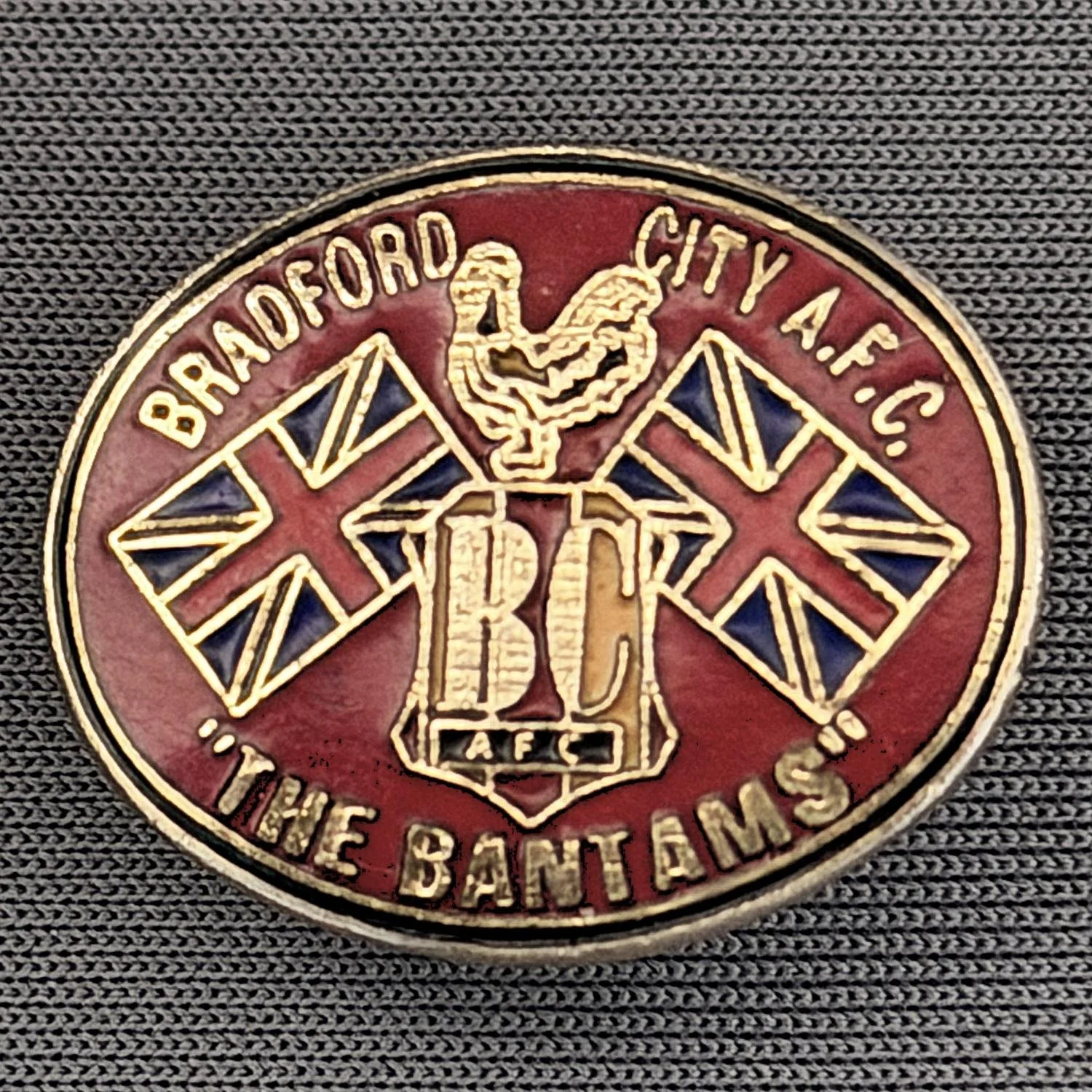 Reference Number: BCMUL001
Size: H 17.9 mm x W 22.1 mm
Pin Type: Metal Clutch
Plating: Gold
Value: £8
Manufacturer: Unknown
Comments: Bradford City, The Bantams, Union Flag