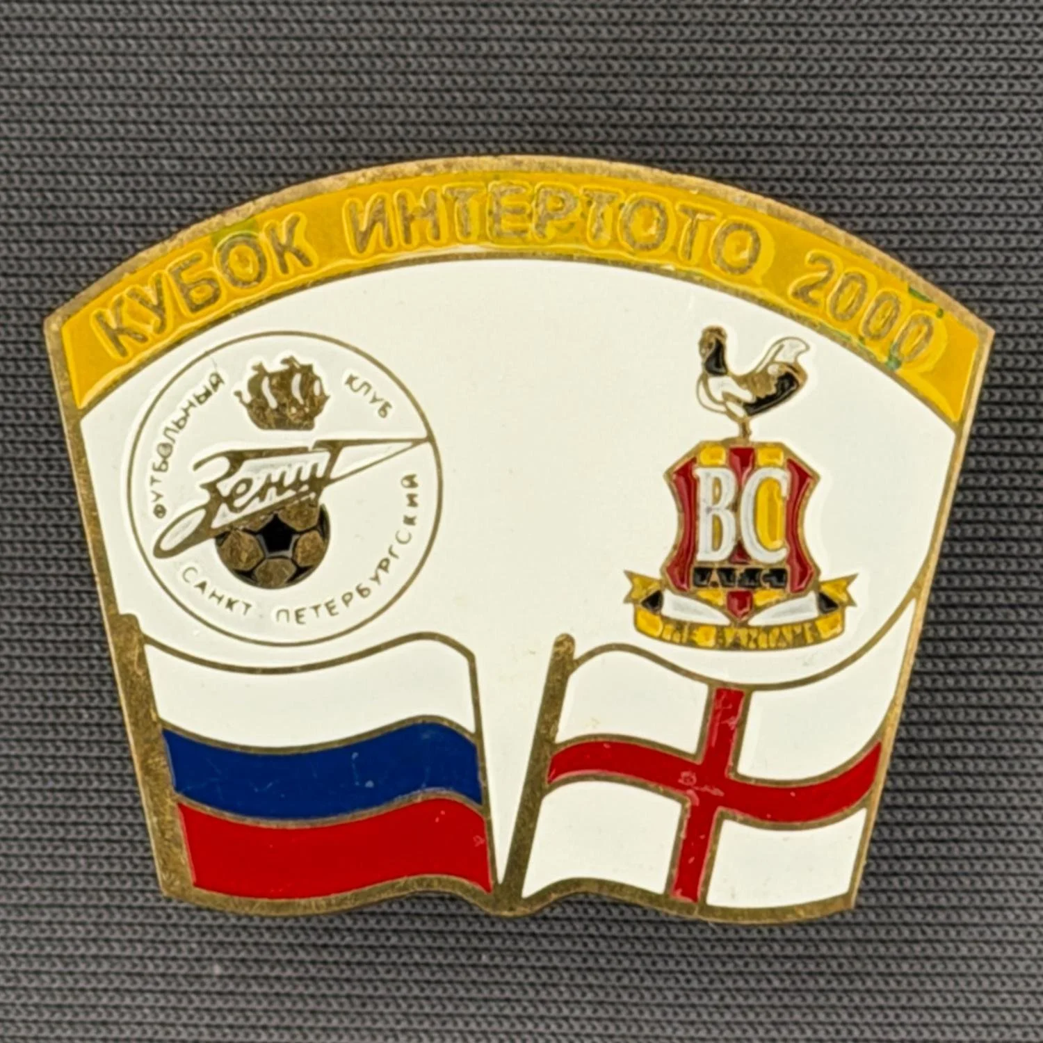 Reference Number: BCRUS027
Size: H 26 mm x W 32.3 mm
Pin Type: Metal Clutch
Plating: Antique Gold
Value: £12
Manufacturer: Unknown
Comments: Zenit St. Petersburg Inter Toto Cup, Yellow Top, White Background
