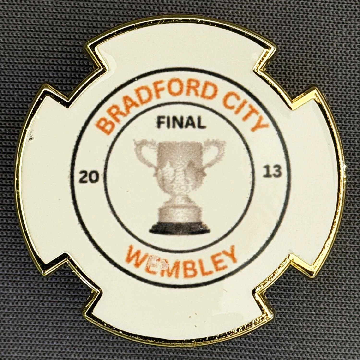 A badge or medal with the words "Bradford City" and "Wembley" around a trophy image, indicating a final match in 2013.