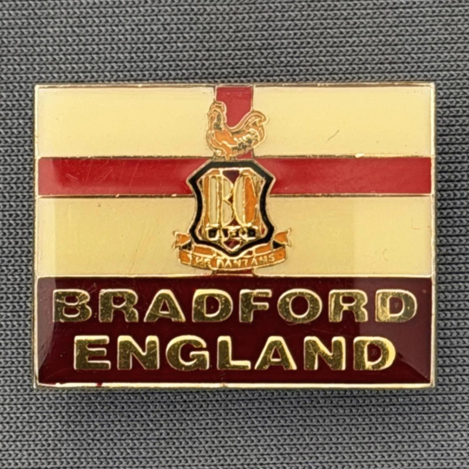 Reference Number: BCFLA010
Size: H 19.5 mm x W 25.5 mm
Pin Type: Brooch Pin
Plating: Gold
Value: £6
Manufacturer: Not Known
Comments: St George Flag, Bradford England & City Logo