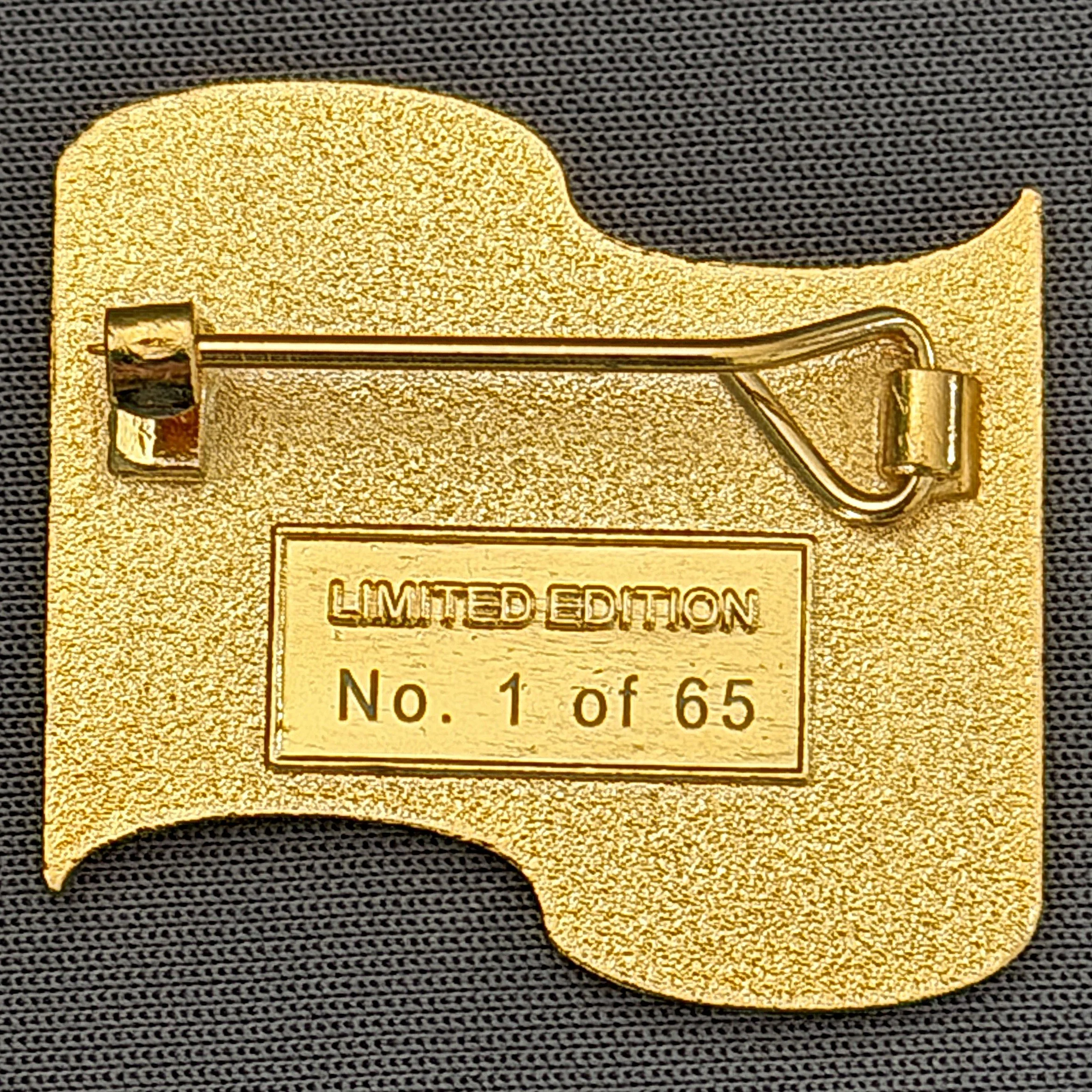 Close-up of a small, gold-colored zipper on a black textured fabric with a warning label indicating it is a limited edition.