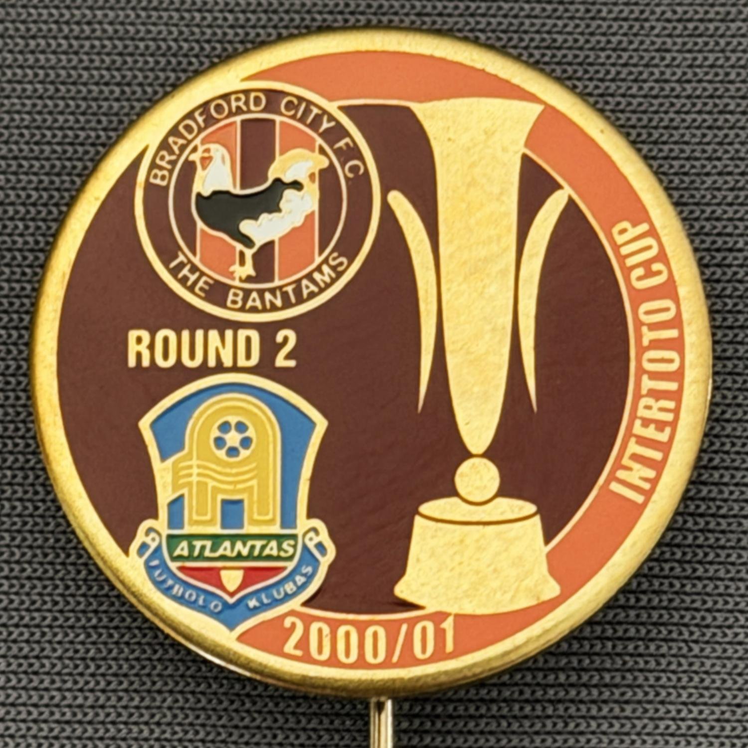 Reference Number: BCRUS039
Size: D 25 mm 
Pin Type: Metal Stick Pin
Plating: Gold
Value: £12
Manufacturer: Unknown
Comments: FK Atlantas Inter Toto Cup, City Logo, Claret & Amber Version