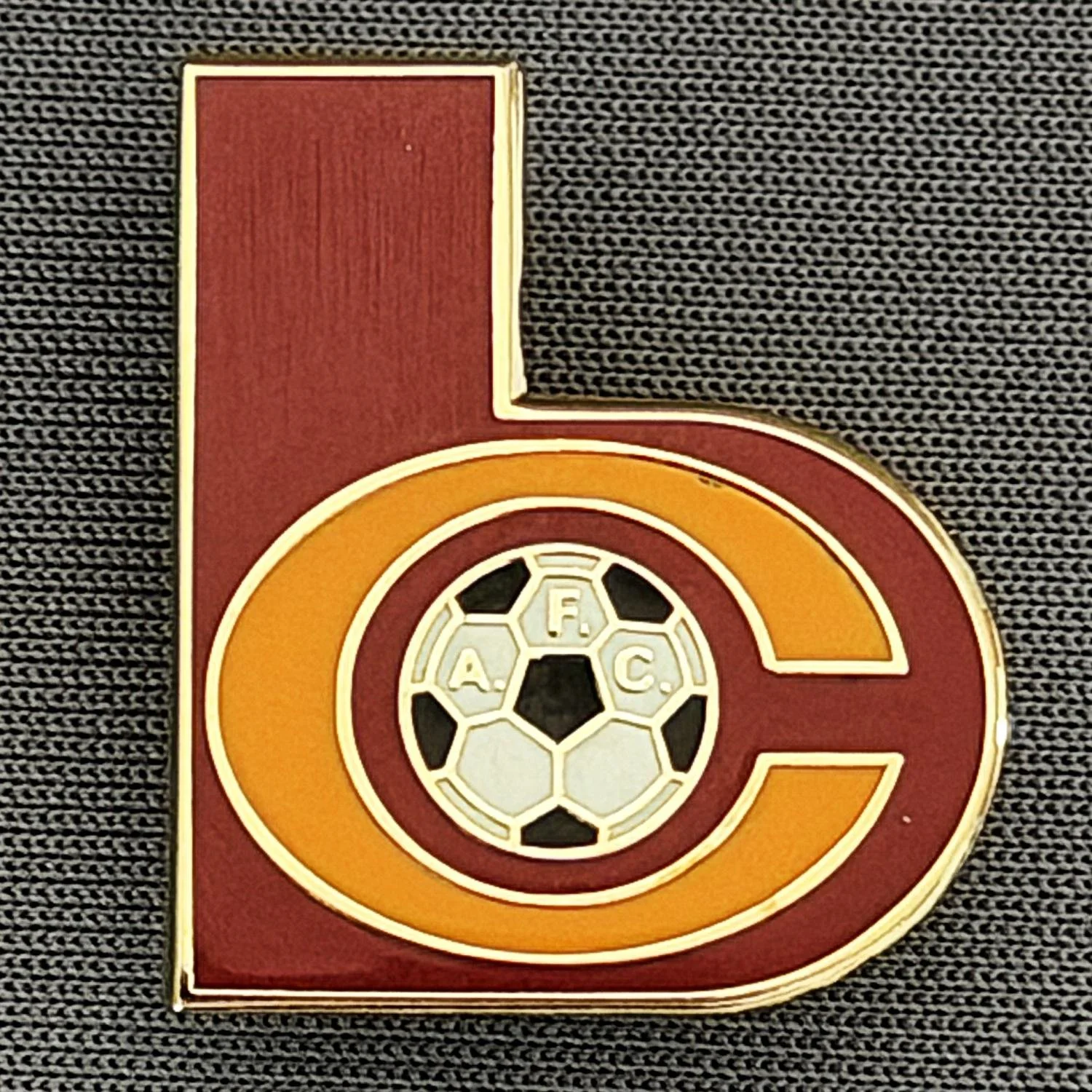 Reference Number: BCC&L150
Size: H 22.8 mm x 19.7 mm
Pin Type: Brooch Pin
Plating: Gold
Value: £6
Manufacturer: Unknown
Comments: Shaped Claret & Amber BC Logo