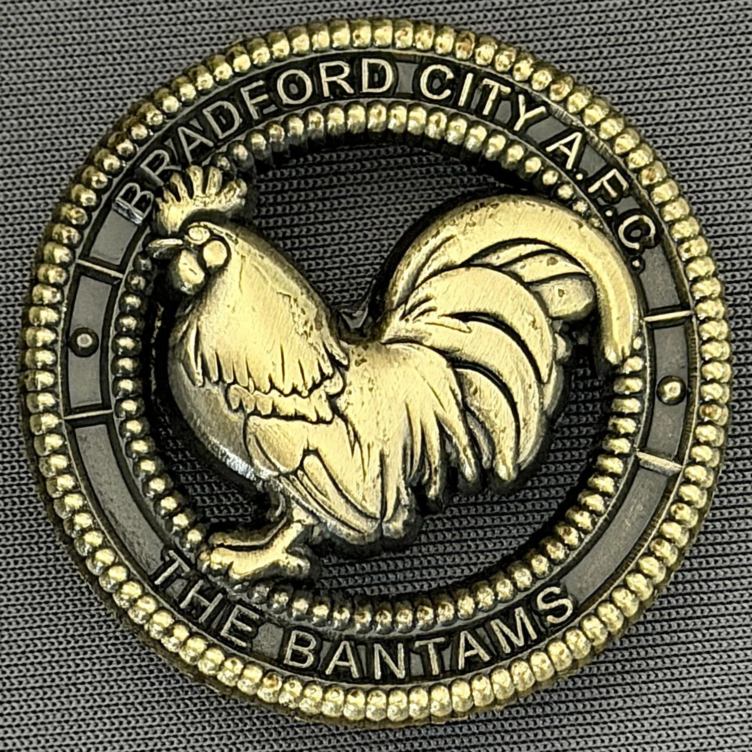 Reference Number: BCBAN082
Size: D 35.3 mm
Pin Type: Brooch Pin
Plating: Antique Gold
Value: £8
Manufacturer: Bradford City Badges
Comments: 3D Antique Bronze, Cut out Bantam. Limited Edition of 12 Badges.