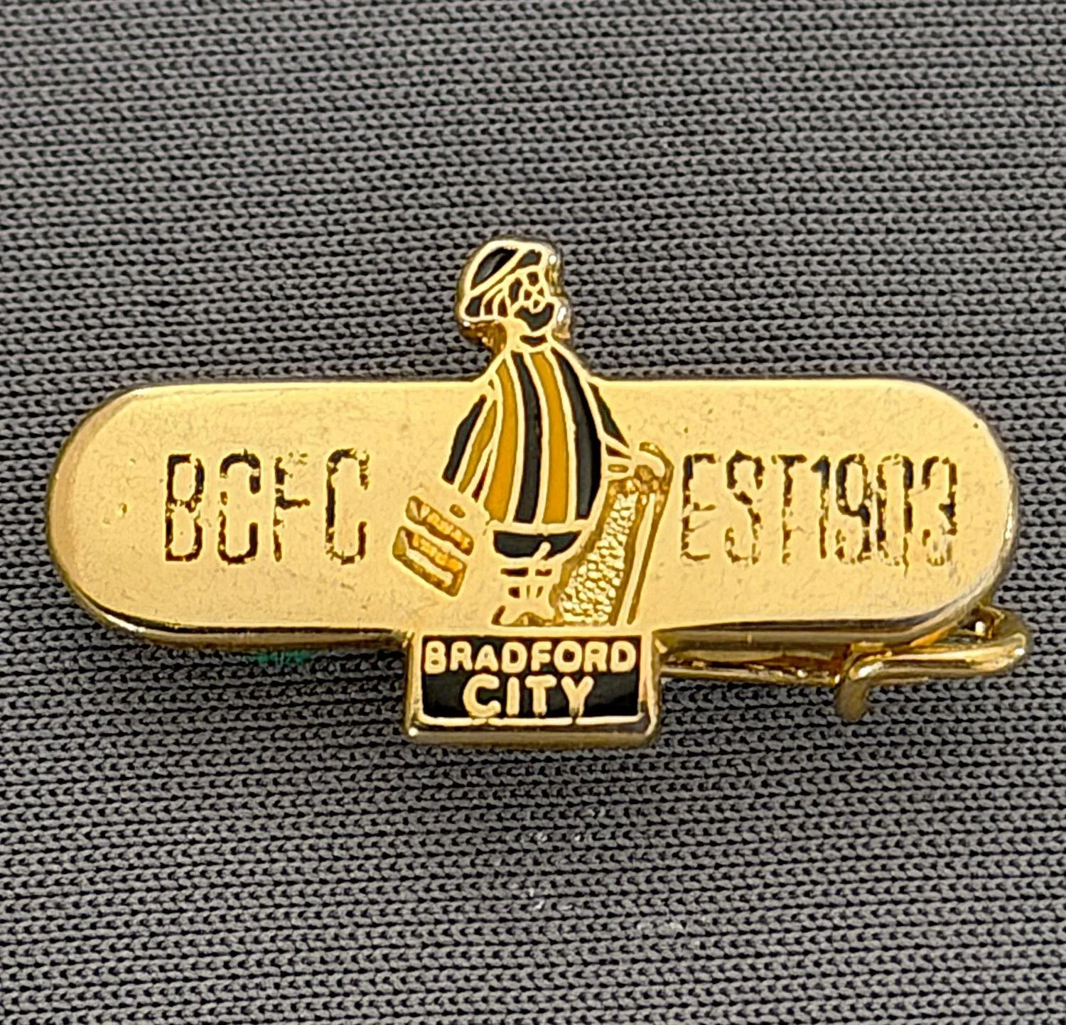 Reference Number: BCGEN029
Size: H 13.2 mm x W 24.8 mm
Pin Type: Brooch Pin
Plating: Gold
Value: £8
Manufacturer: Unknown
Comments: Horizontal Bar, City Gent, Black Letters