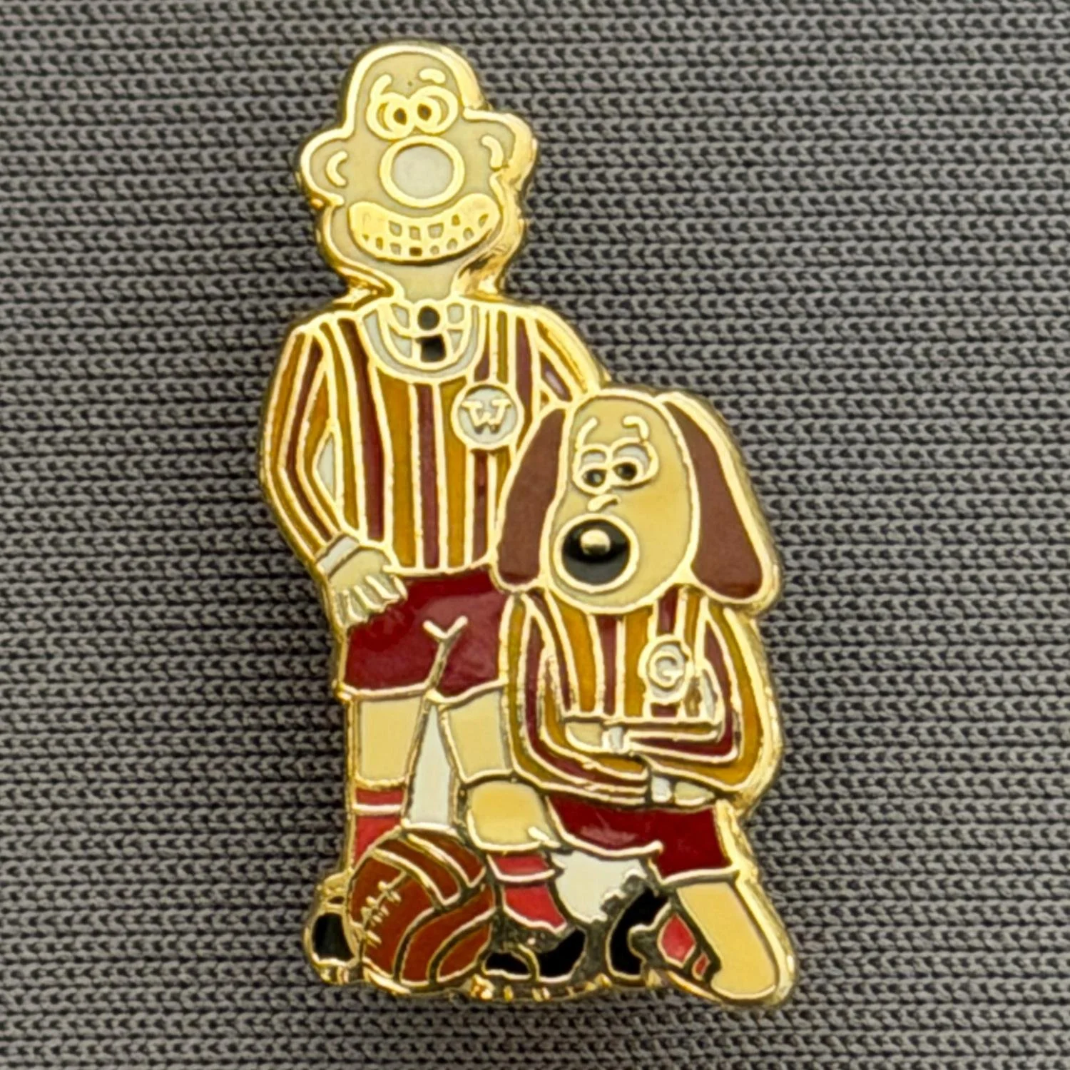 Reference Number: BCCTN020
Size: H 21.9 mm x W 11.9 mm
Pin Type: Brooch Pin
Plating: Gold
Value: £6
Manufacturer: Not Known
Comments: Wallace & Gromit in Bradford City Kit Red Shorts