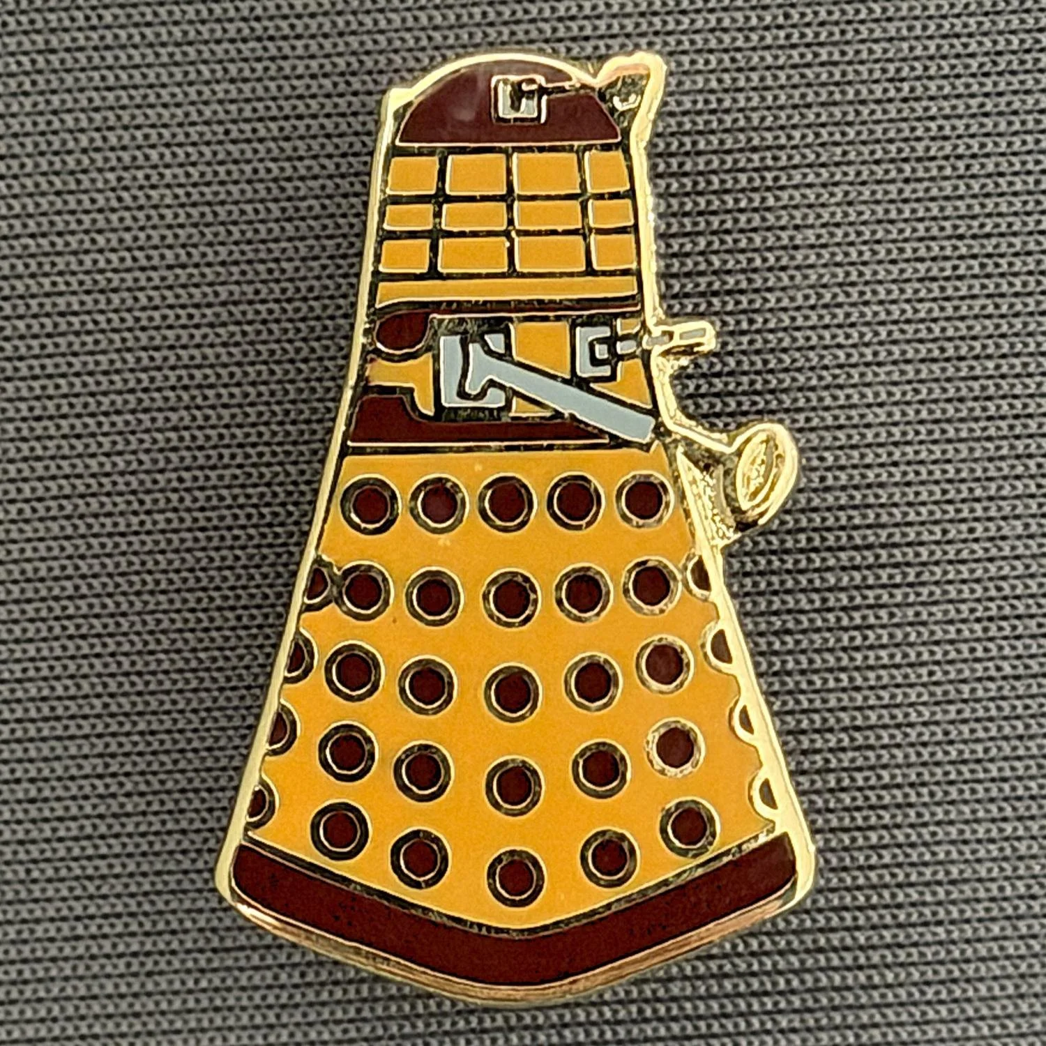 Reference Number: BCUN049
Size: H 28 mm x W 17.5 mm
Pin Type: Plastic Clutch
Plating: Gold
Value: £6
Manufacturer: Unknown
Comments: Amber & Claret Dalek
