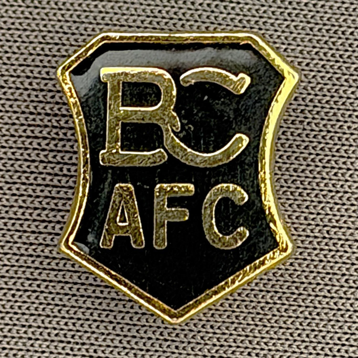 Reference Number: BCC&L035
Size: H 14.4 mm x W 12.1 mm
Pin Type: Brooch Pin
Plating: Gold
Value: £8
Manufacturer: Unknown
Comments: Black BCAFC Shield
