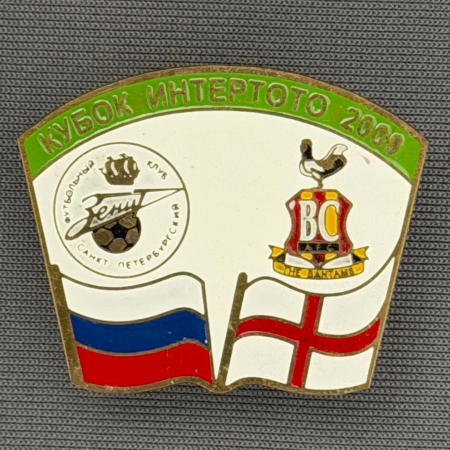 Reference Number: BCRUS024
Size: H 26 mm x W 32.3 mm
Pin Type: Metal Clutch
Plating: Antique Gold
Value: £12
Manufacturer: Unknown
Comments: Zenit St. Petersburg Inter Toto Cup, Green Top, White Background