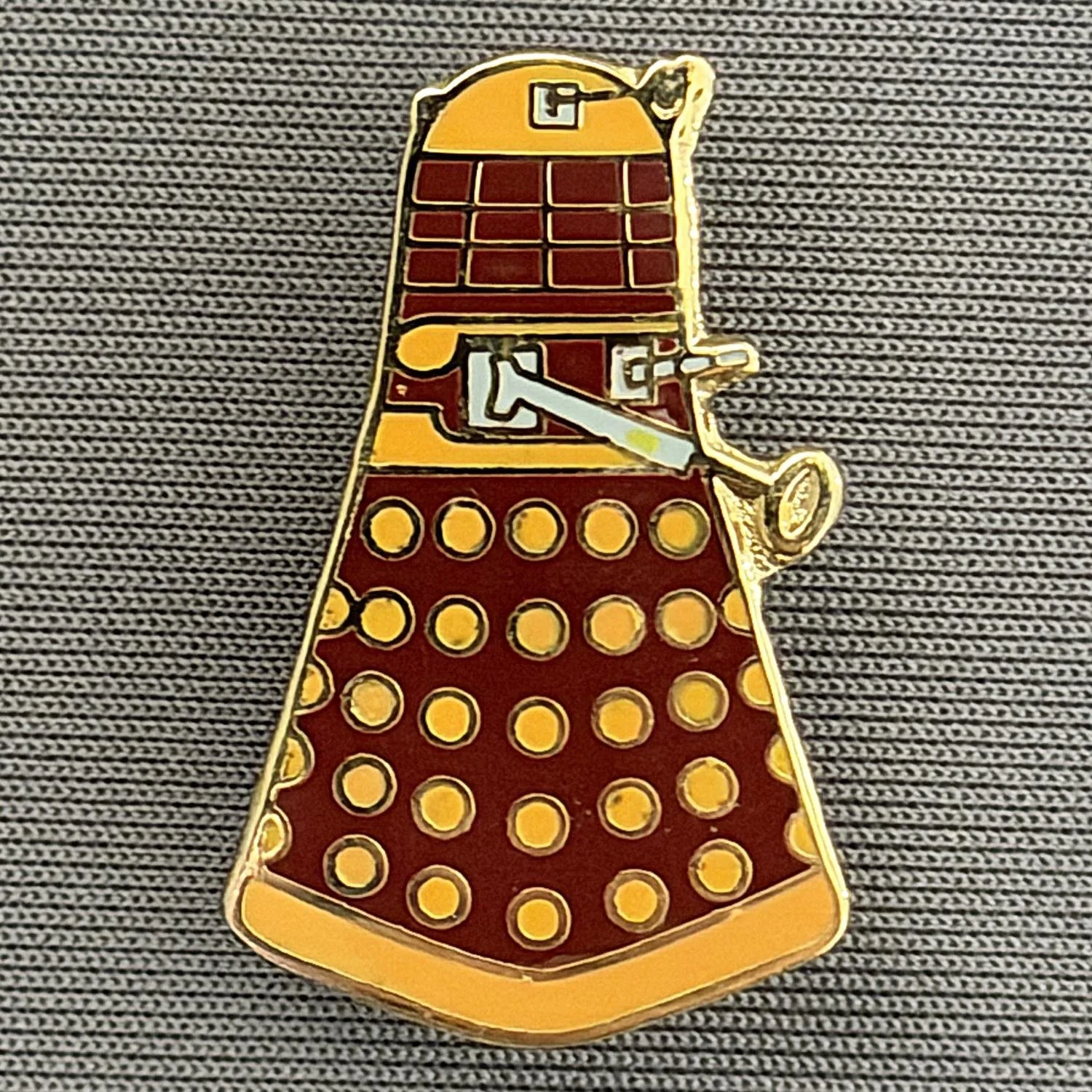 Reference Number: BCUN048
Size: H 28 mm x W 17.5 mm
Pin Type: Plastic Clutch
Plating: Gold
Value: £6
Manufacturer: Unknown
Comments: Claret & Amber Dalek