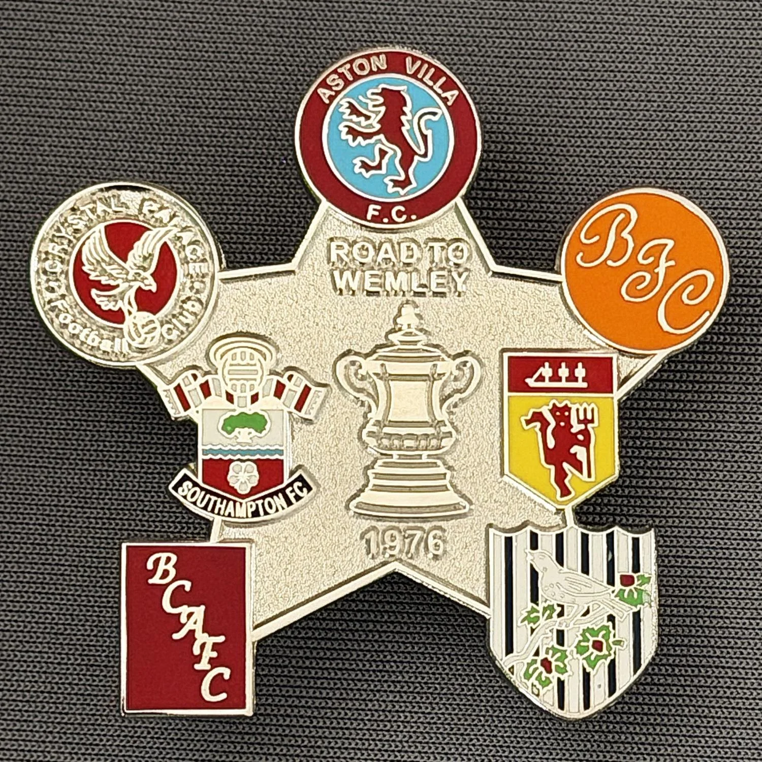 Reference Number: BCFAC048
Size: H 40.8 mm x W 42.1 mm
Pin Type: Double Metal Clutch
Plating: Silver
Value: £5
Manufacturer: Dan Lloyd
Comments: Road to Wembley 1976 Silver Version