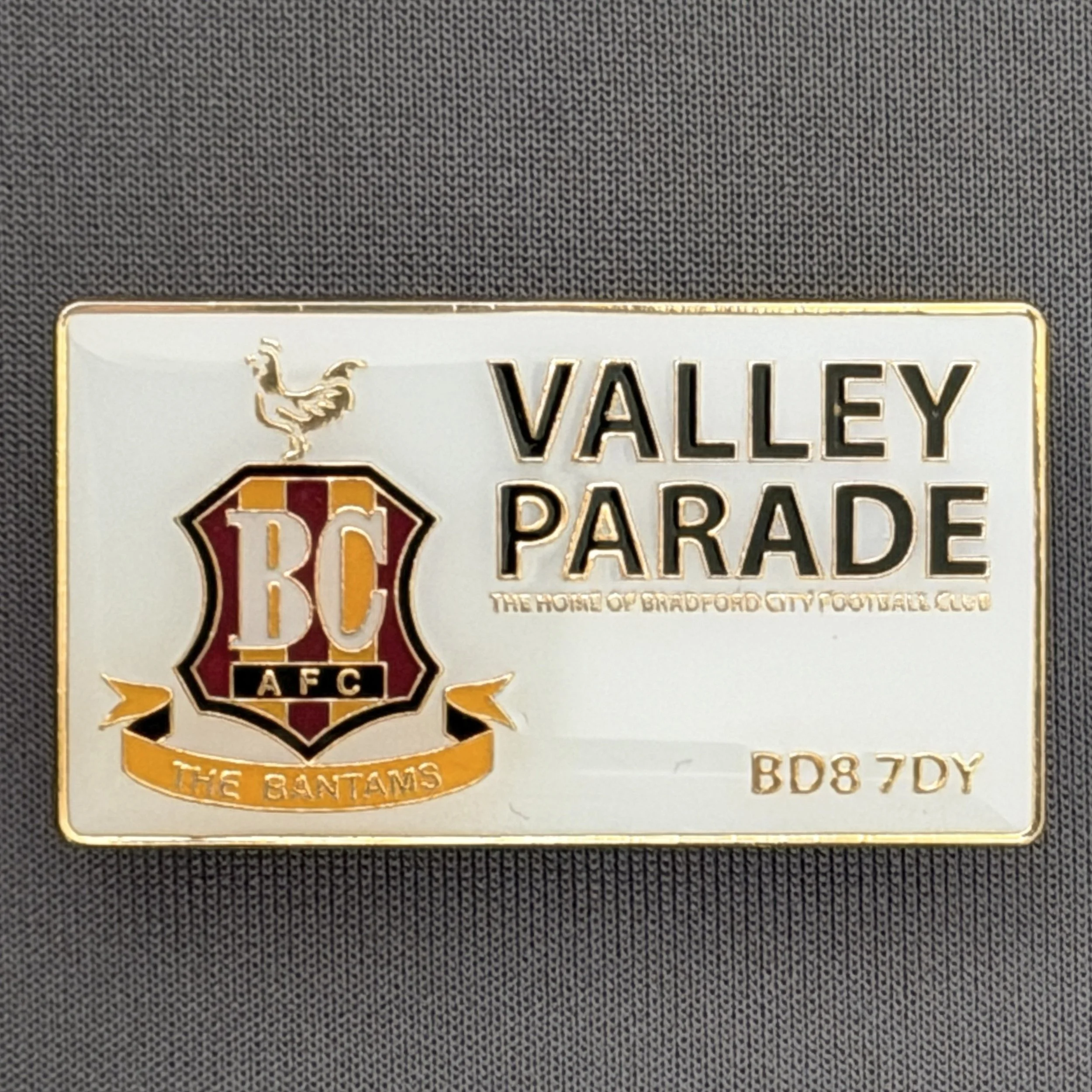Reference Number: BCVP011
Size: H 22.2 mm x W 40.3 mm
Pin Type: Metal Clutch
Plating: Gold
Value: £6
Manufacturer: Bradford City Shop
Comments: Valley Parade City Logo
