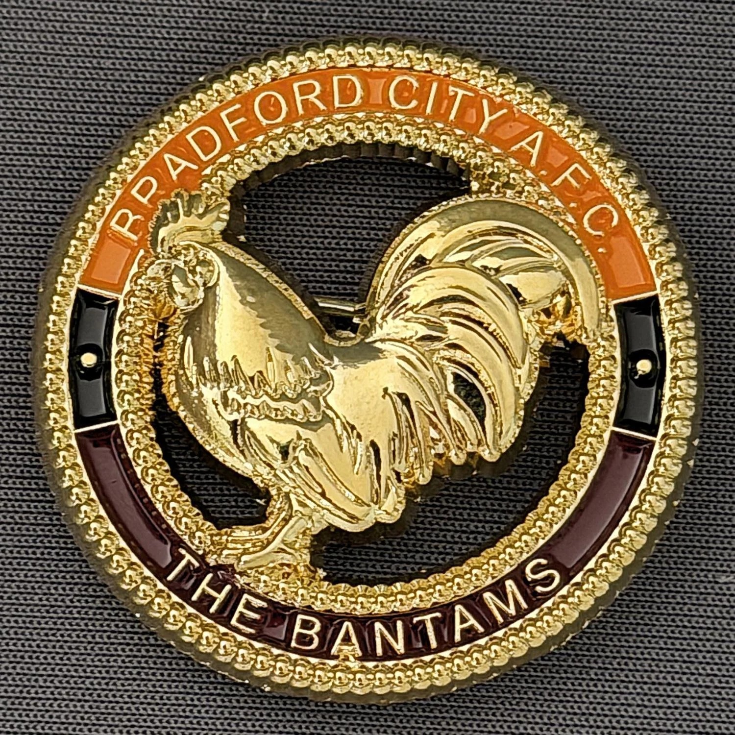 Close-up of the Mexico City badge with a rooster emblem, gold and red accents, and the text "Ud. H. Bd. F. Ord City Afe. C. The Bantams."