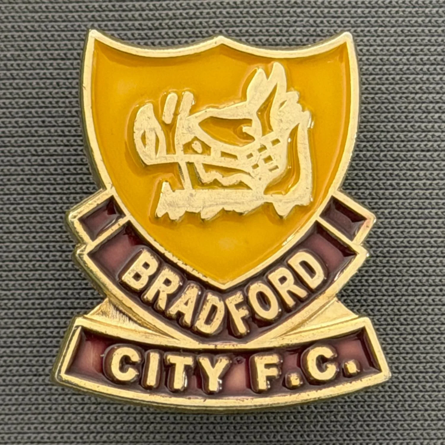 Reference Number: BCBOH055
Size: H 22.8 x W 20.4 mm
Pin Type: Brooch Pin
Plating: Gold
Value: £6
Manufacturer: Unknown
Comments: Amber & Claret Boar's Head Shield