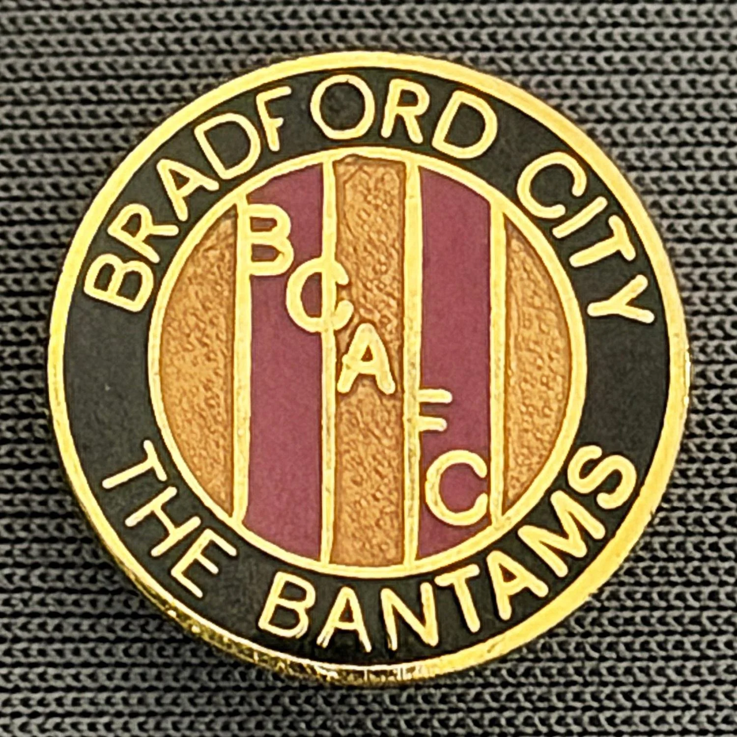 Reference Number: BCBCFC014
Size: D 15.2 mm
Pin Type: Brooch Pin
Plating: Gold
Value: £8
Manufacturer: Unknown
Comments: Bradford City, BCAFC, The Bantams, Black, Claret & Amber Version