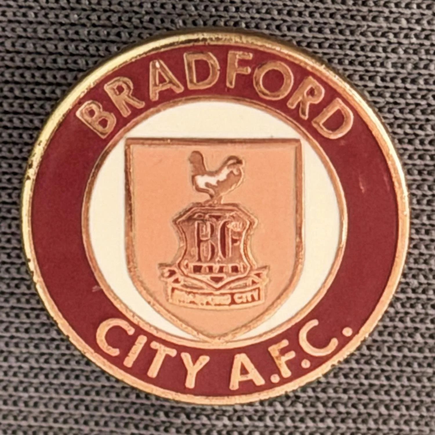Reference Number: BCC&L019
Size: D 14.7 mm
Pin Type: Brooch Pin
Plating: Gold
Value: £6
Manufacturer: Unknown
Comments: Tiny Circular Claret & Amber Shield Logo