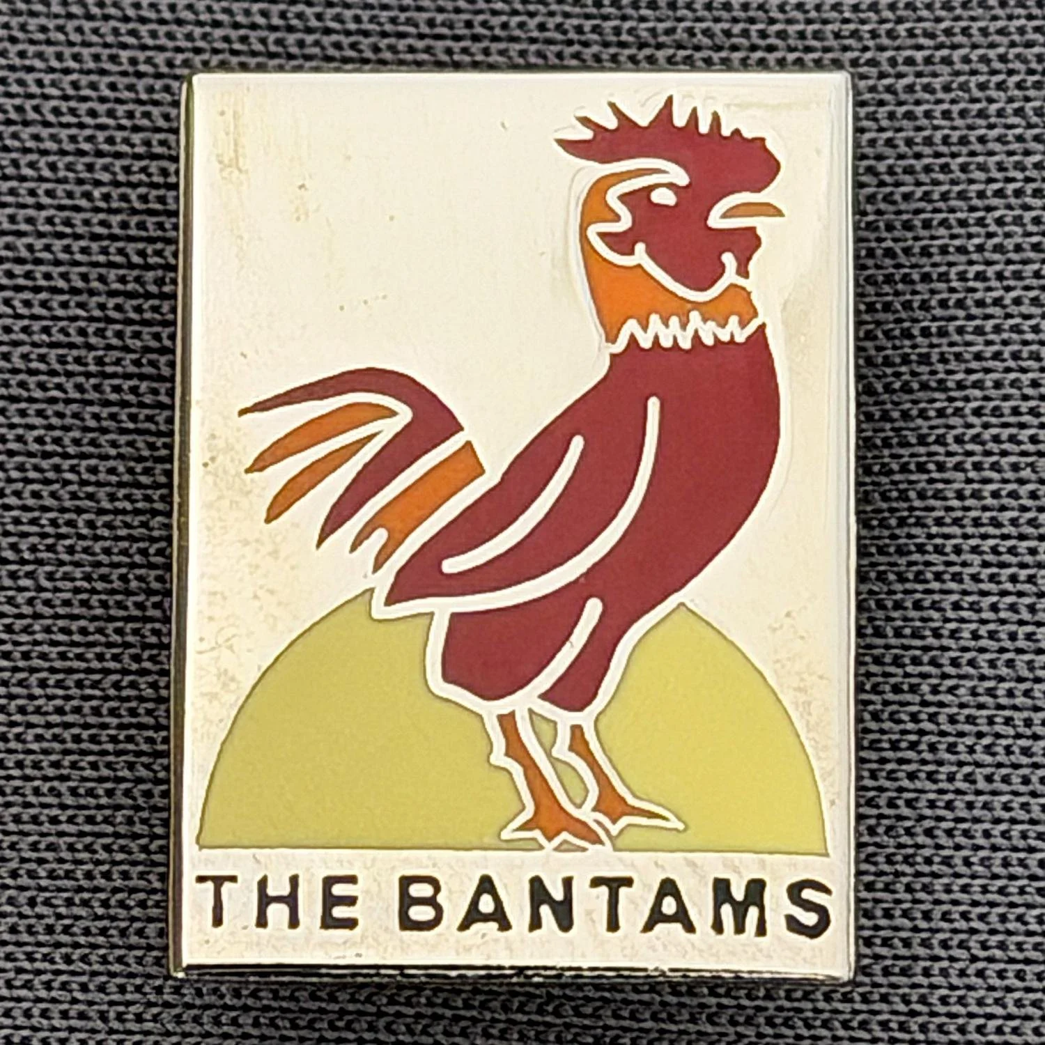 Reference Number: BCBAN024
Size: H 20 mm x W 14.4 mm
Pin Type: Brooch Pin
Plating: Silver
Value: £8
Manufacturer: Paraders
Comments: Small Oblong Bantam Crest