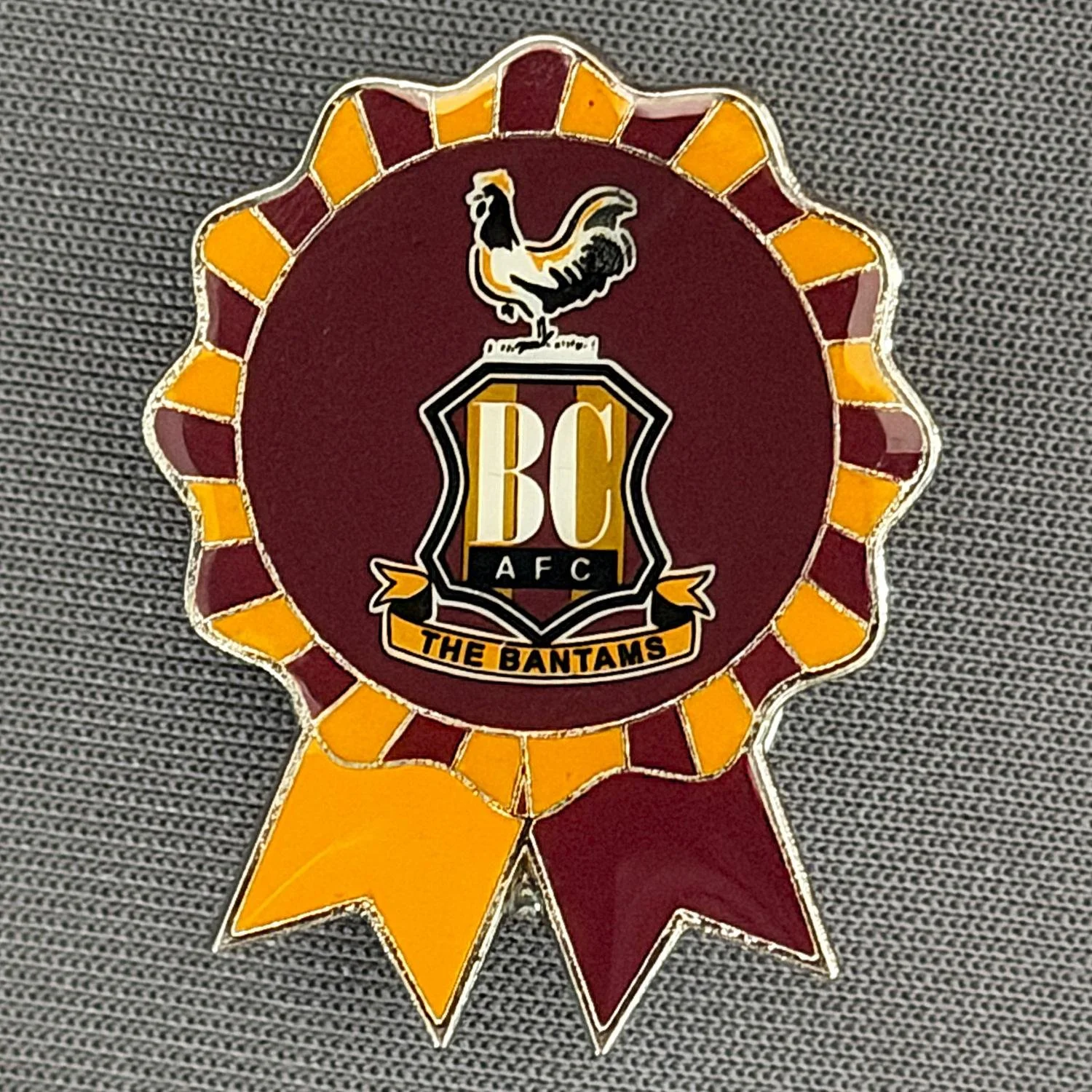 Reference Number: BCC&L163
Size: H 29.9 mm x 23.3 mm
Pin Type: Metal Clutch
Plating: Silver
Value: £6
Manufacturer: Bradford City Shop
Comments: City Crest Rosette