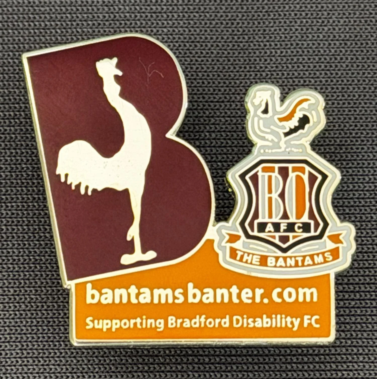 Reference Number: BCSUP027
Size: H 23.7 mm x W 22.3 mm
Pin Type: Metal Clutch
Plating: Silver
Value: £12
Manufacturer: Bradford City Badges
Comments: Bantams Banter Claret & Amber Limited Edition of 150