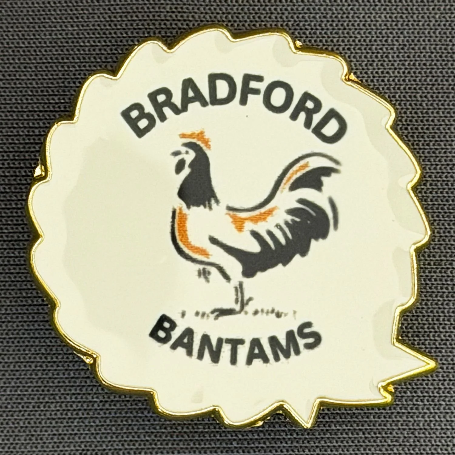 Reference Number: BCBAN092
Size: H 25 mm x W 22.1 mm
Pin Type: Metal Clutch
Plating: Gold
Value: £6
Manufacturer: Artgraph
Comments: White Bradford Bantams Rosette