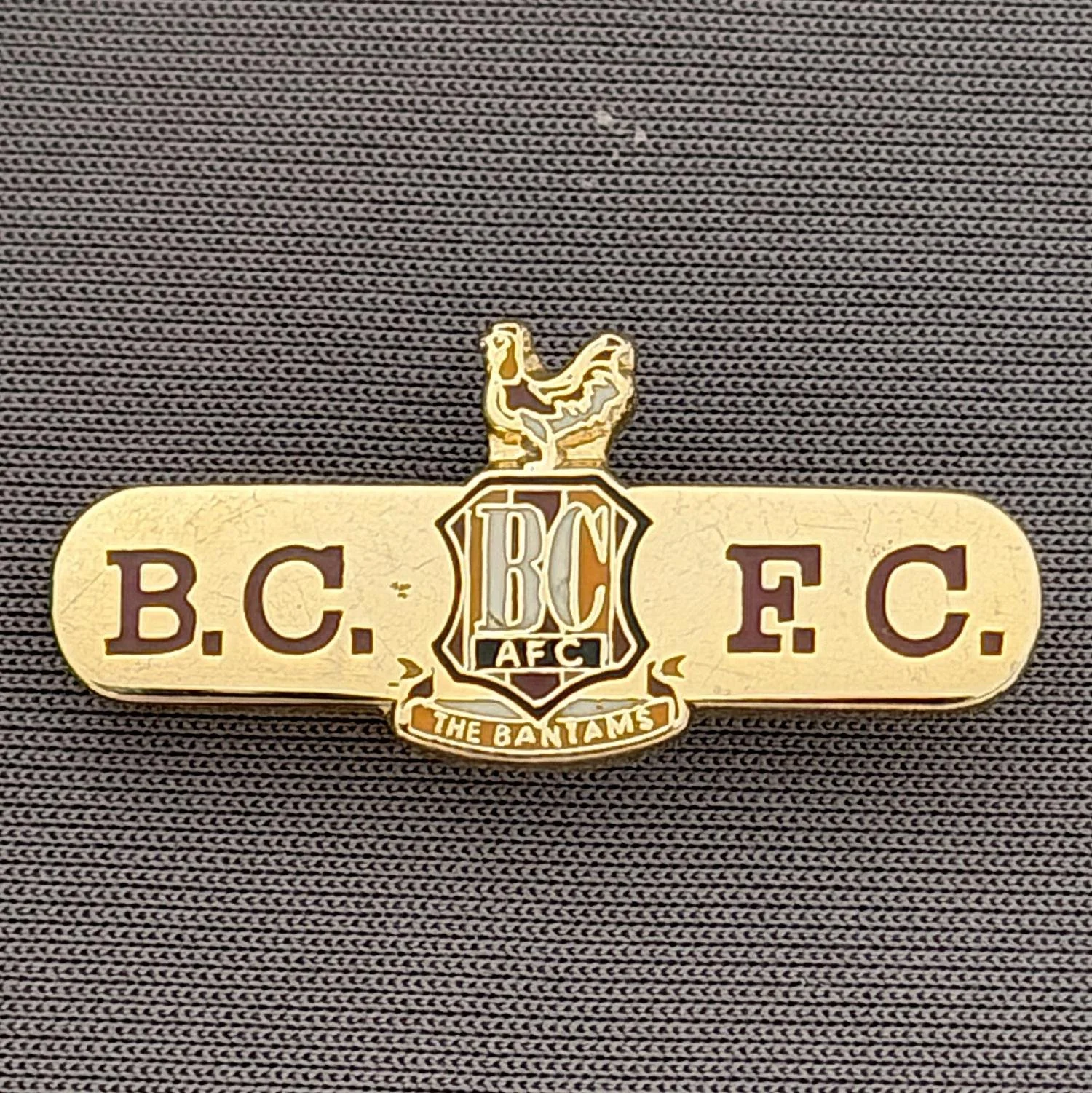 Reference Number: BCC&L036
Size: H 13.8 mm x 30 mm
Pin Type: Brooch Pin
Plating: Gold
Value: £8
Manufacturer: Unknown
Comments: BCFC Bar City Logo