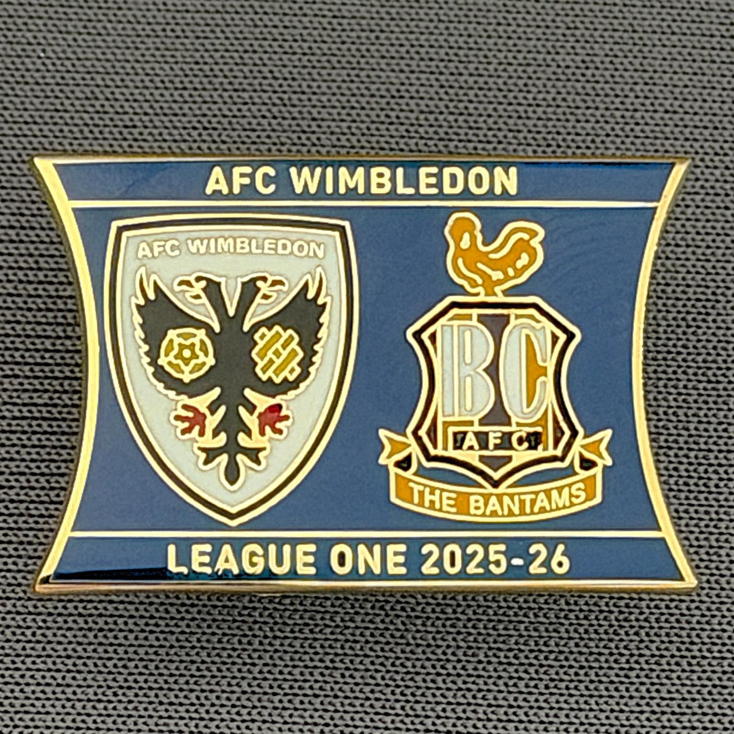Reference Number: BCOFIX115
Size: H 17.4 mm x W 26.1 mm
Pin Type: Rubber Clutch
Plating: Gold
Value: £5
Manufacturer: Terry's Badges
Comments: A.F.C. Wimbledon v Bradford City, League One 2025/26