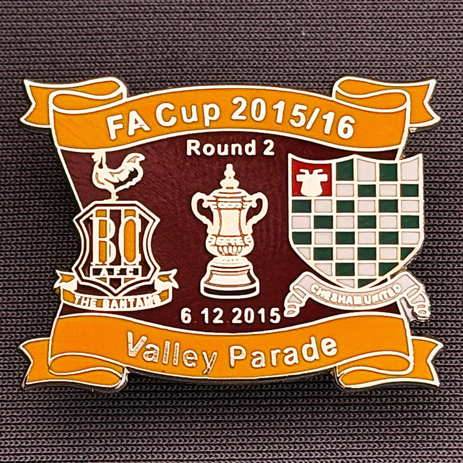 Reference Number: BCFAC139
Size: H 24.5 mm x W 32.5 mm
Pin Type: Metal Clutch
Plating: Silver
Value: £4
Manufacturer: Dan Lloyd
Comments: F.A. Cup Second Round 2015/16 v Chesham United, Amber & Claret Version
