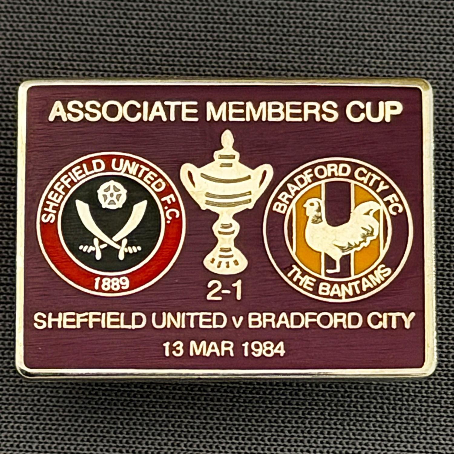 Reference Number: BCOFIX056
Size: H 18.9 mm x W 25.9 mm
Pin Type: Brooch Pin
Plating: Silver
Value: £6
Manufacturer: Unknown
Comments: Sheffield United v Bradford City Associate Members Cup 1984, Claret Version