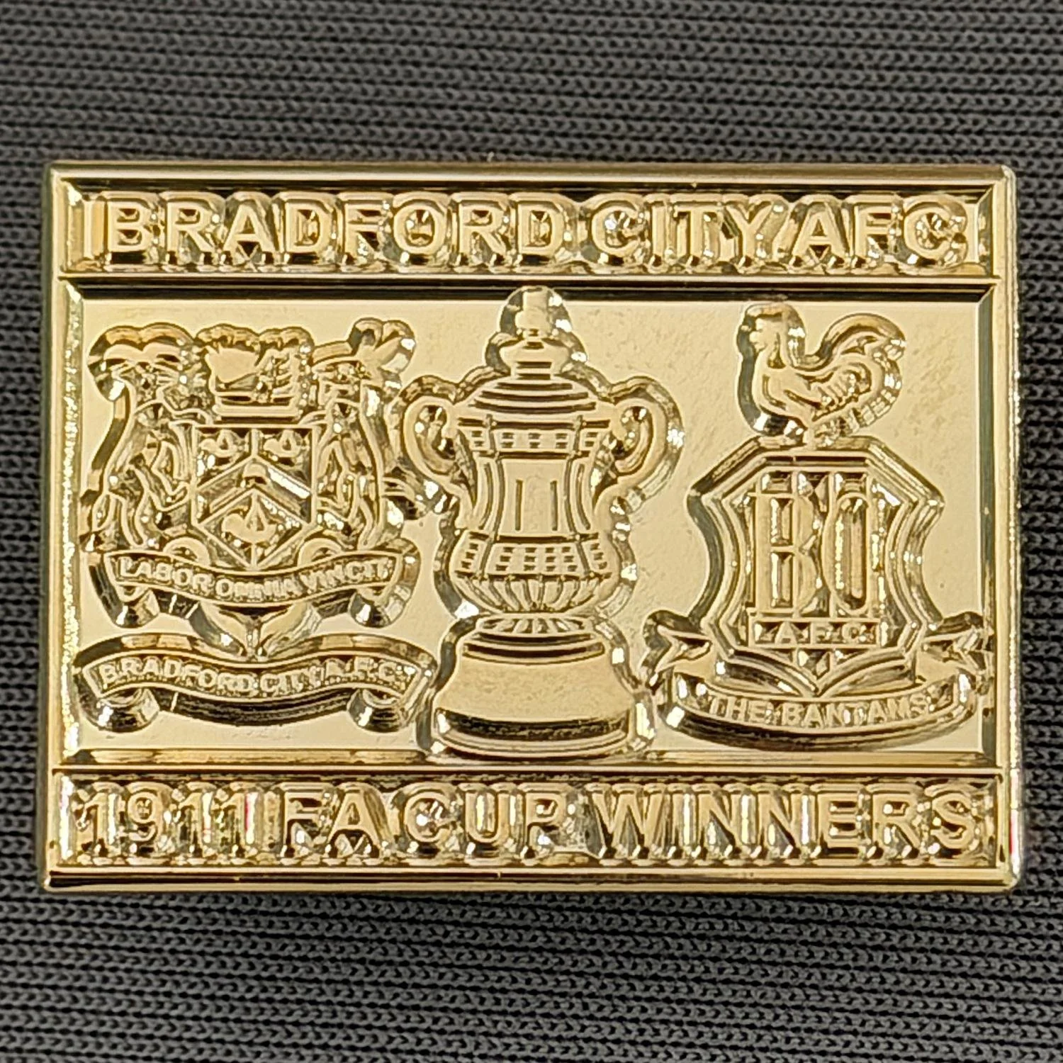 Reference Number: BCFAC042
Size: H 20.4 mm x W 26.8 mm
Pin Type: Metal Clutch
Plating: Gold
Value: £5
Manufacturer: Dan Lloyd
Comments: Bradford City 1911 F.A. Cup Winners, Gold Version