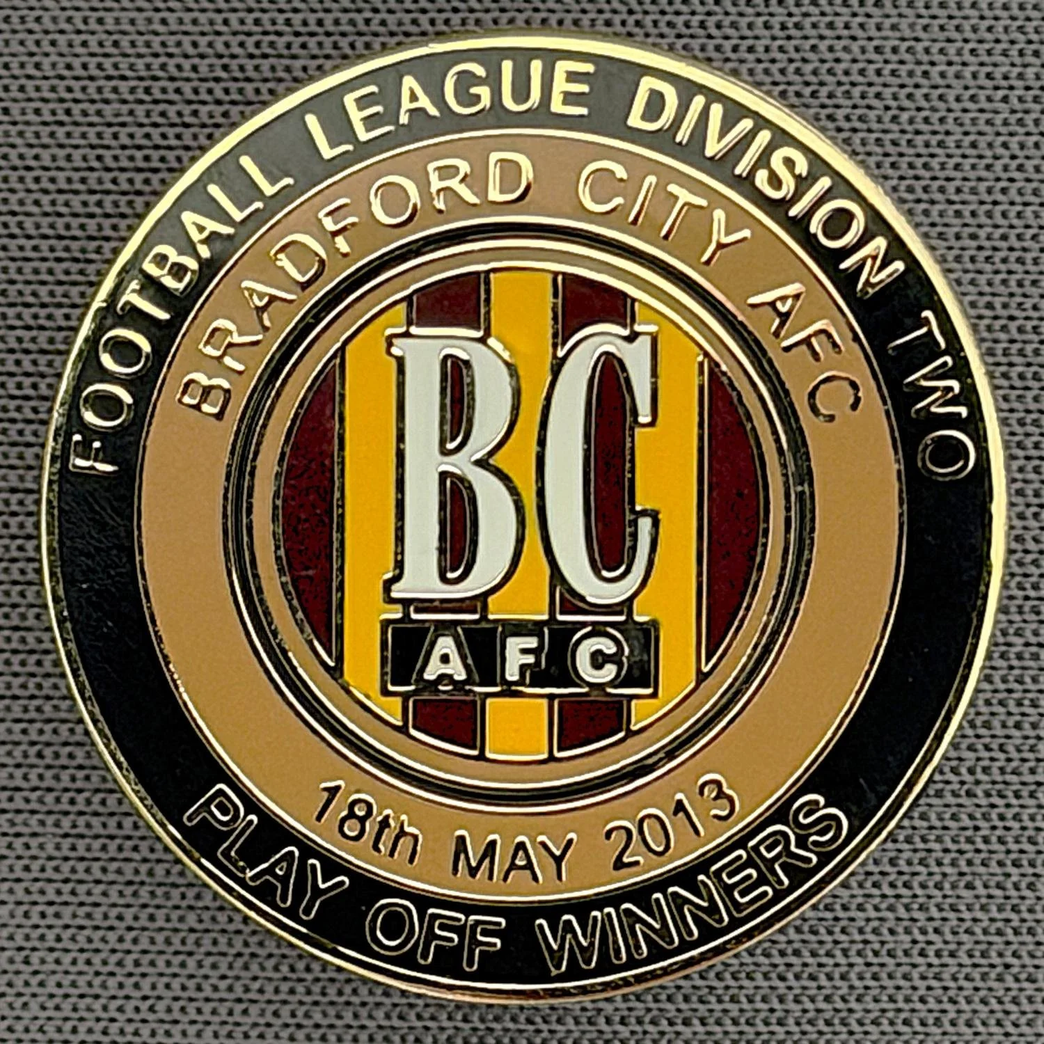 Reference Number: BCEVE070
Size: D 24.2 mm
Pin Type: Metal Clutch
Plating: Gold
Value: £8
Manufacturer: Dave Horn
Comments: 2013 Div 2 Play Off Winners, 
Black & Gold. Boxed Set Limited Edition of 25