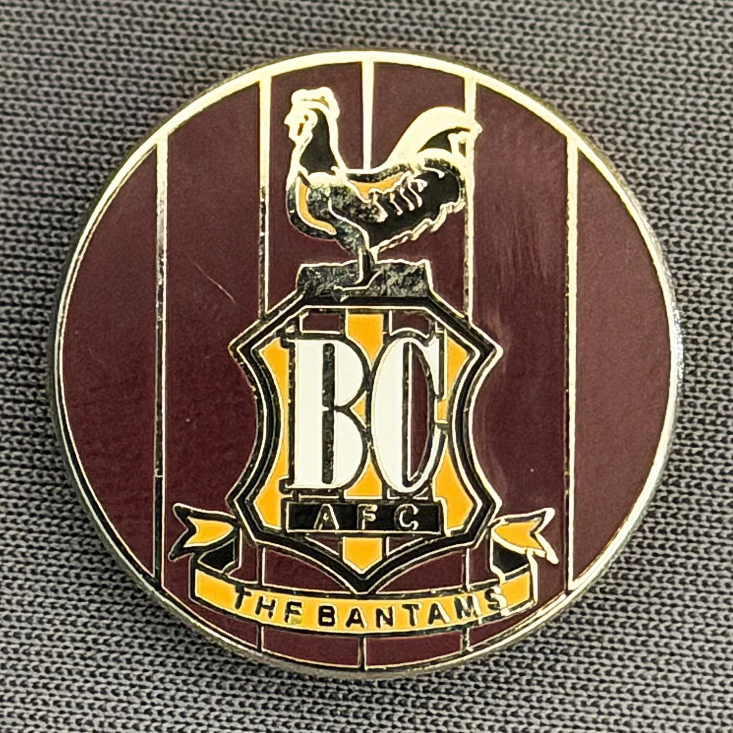 A pin or badge with the AFC logo, a lion, and the text 'The Bantams'.