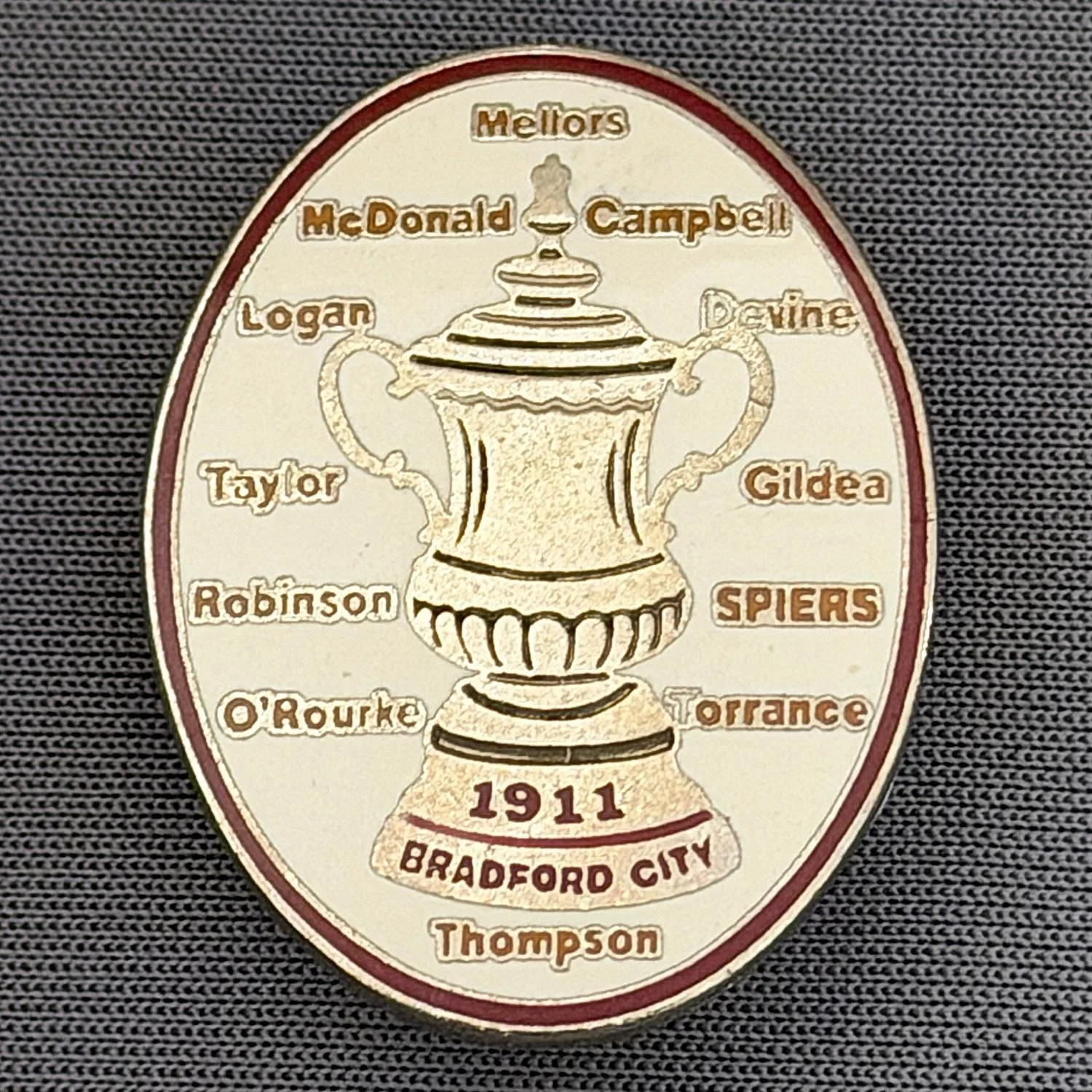 Reference Number: BCEVE016
Size: H 29.5 mm x W 23 mm
Pin Type: Brooch Pin
Plating: Gold
Value: £10
Manufacturer: Unknown
Comments: White, 1911 City Cup Winning Squad, Amber Text.