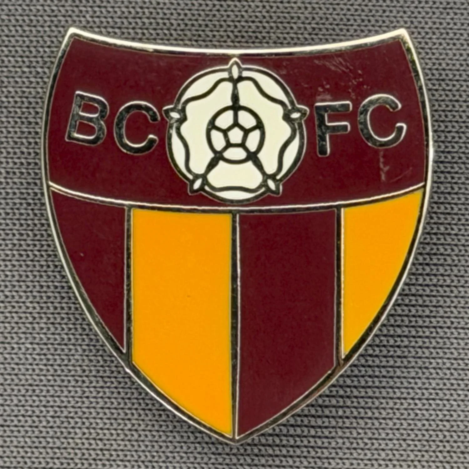 Reference Number: BCYR023
Size: H 25 mm x W 22.8 mm
Pin Type: Brooch Pin
Plating: Gold
Value: £6
Manufacturer: Unknown
Comments: BCFC Yorkshire Rose Claret & Amber Shield. Larger version.