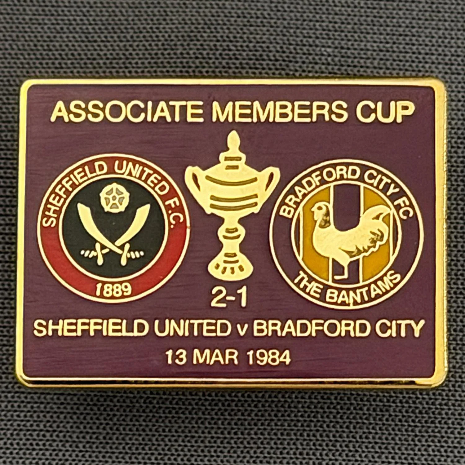Reference Number: BCOFIX055
Size: H 18.9 mm x W 25.9 mm
Pin Type: Brooch Pin
Plating: Gold
Value: £6
Manufacturer: Unknown
Comments: Sheffield United v Bradford City Associate Members Cup 1984, Claret Version