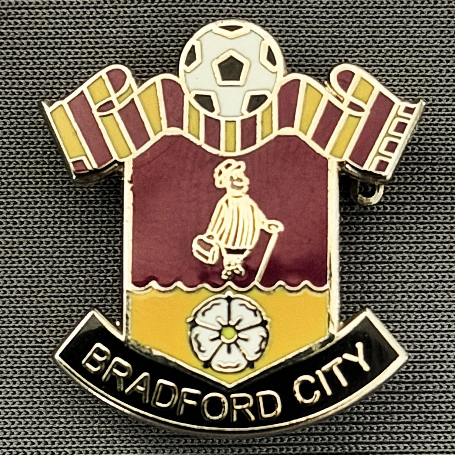 Reference Number: BCMUL018
Size: H 24.2 mm x W 22.3 mm
Pin Type: Brooch Pin
Plating: Silver
Value: £8
Manufacturer: Andy Stokes
Comments: Claret & Amber City Scarf, City Gent, Yorkshire Rose