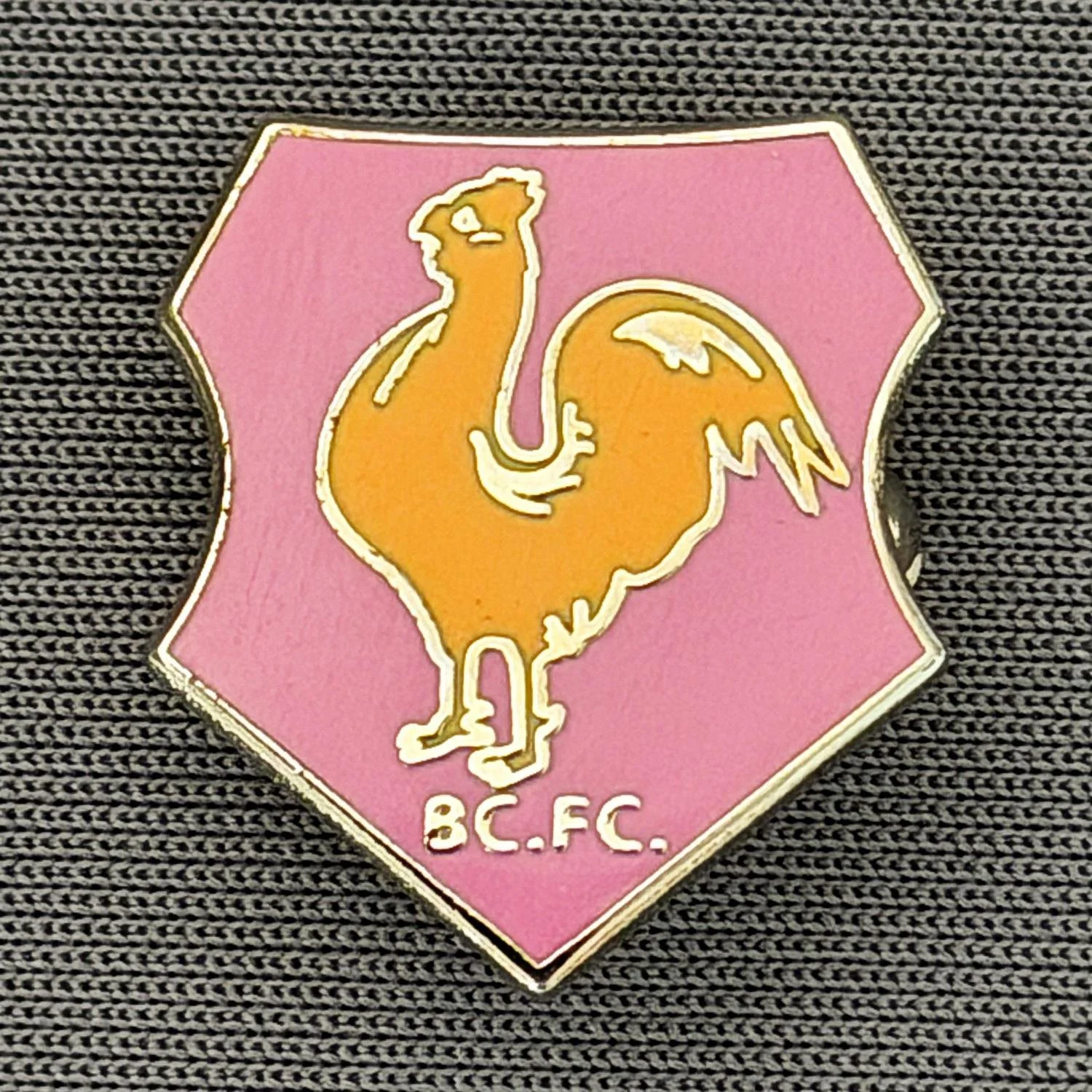 Reference Number: BCBAN060
Size: H 18.6 mm x W 16.6 mm
Pin Type: Brooch Pin
Plating: Silver
Value: £6
Manufacturer: Unknown
Comments: Pink & Amber, Bantam Crest Shield 