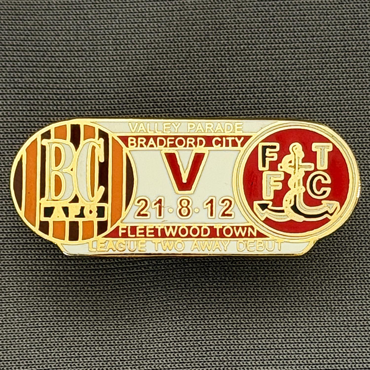 Reference Number: BCOFIX133
Size: H 14.4 mm x W 35.1 mm
Pin Type: Double Rubber Clutch
Plating: Gold
Value: £5
Manufacturer: Unknown
Comments: Bradford City v Fleetwood Town 2012 League Two Debut, White & Red Version 