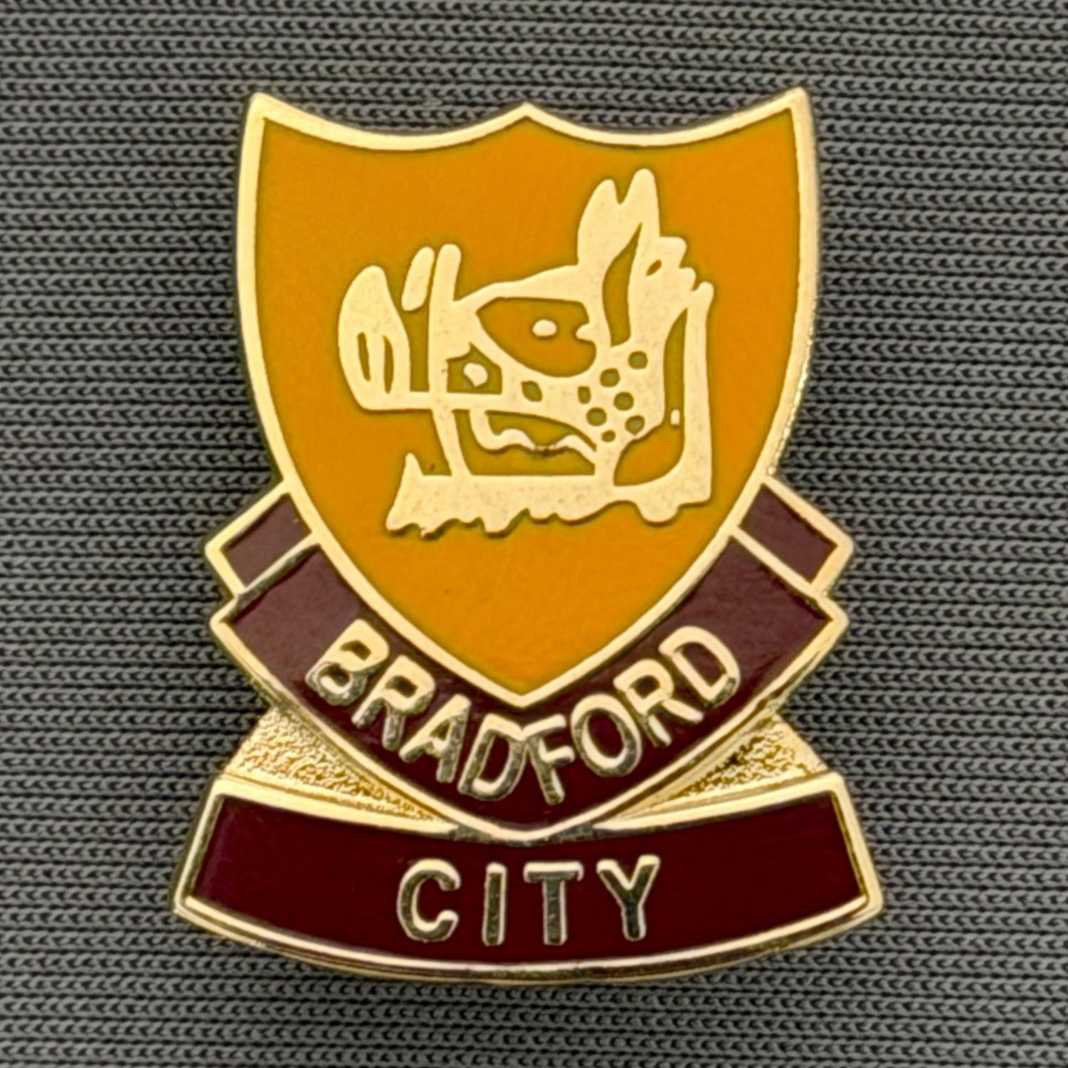 Reference Number: BCBOH058
Size: H 23.8 x W 19.1 mm
Pin Type: Brooch Pin
Plating: Gold
Value: £6
Manufacturer: Unknown
Comments: Amber & Claret Boar's Head Shield