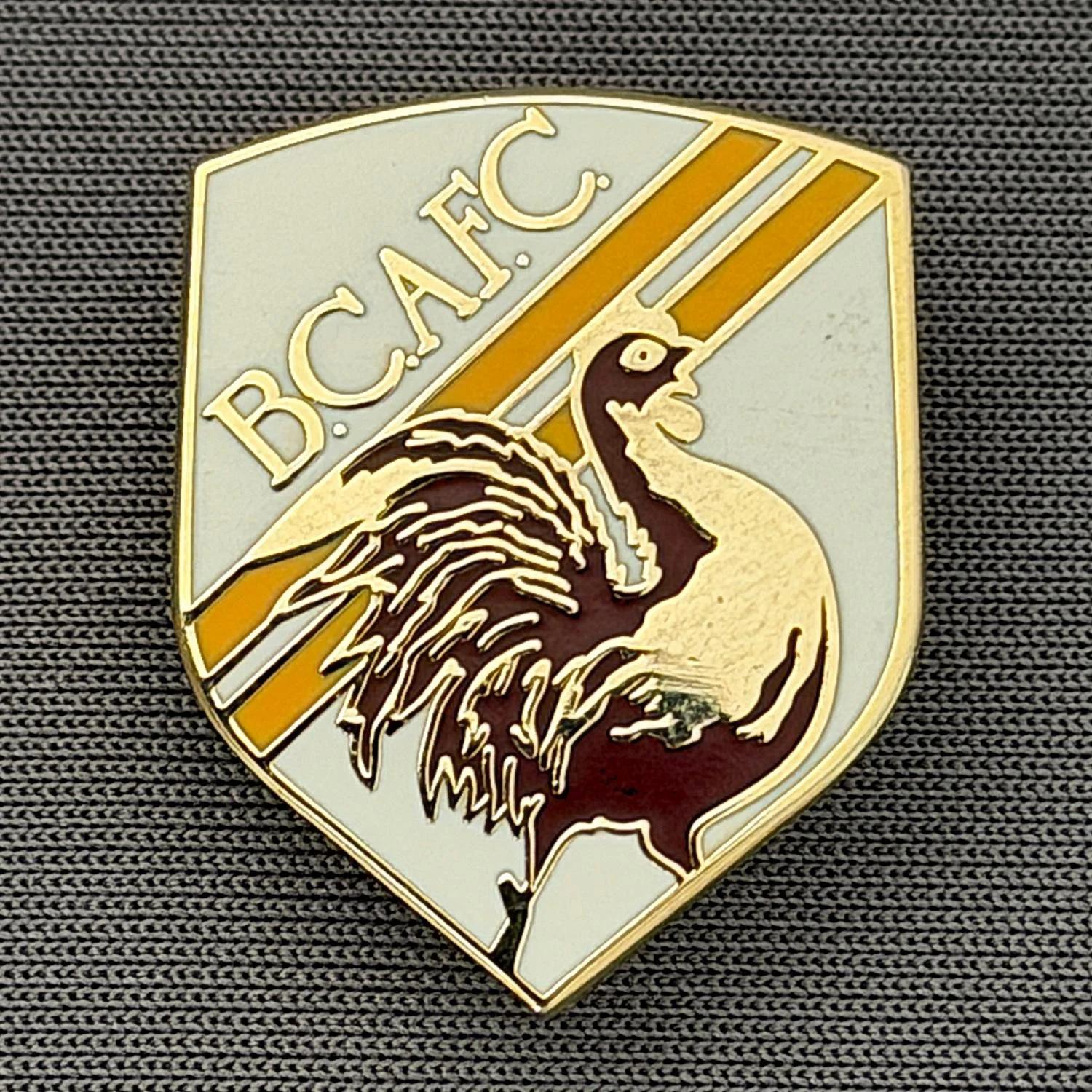 Reference Number: BCBAN050
Size: H 24.1 mm x W 19.4. mm
Pin Type: Brooch Pin
Plating: Gold
Value: £6
Manufacturer: Unknown
Comments: White, Claret & Amber Bantam Shield