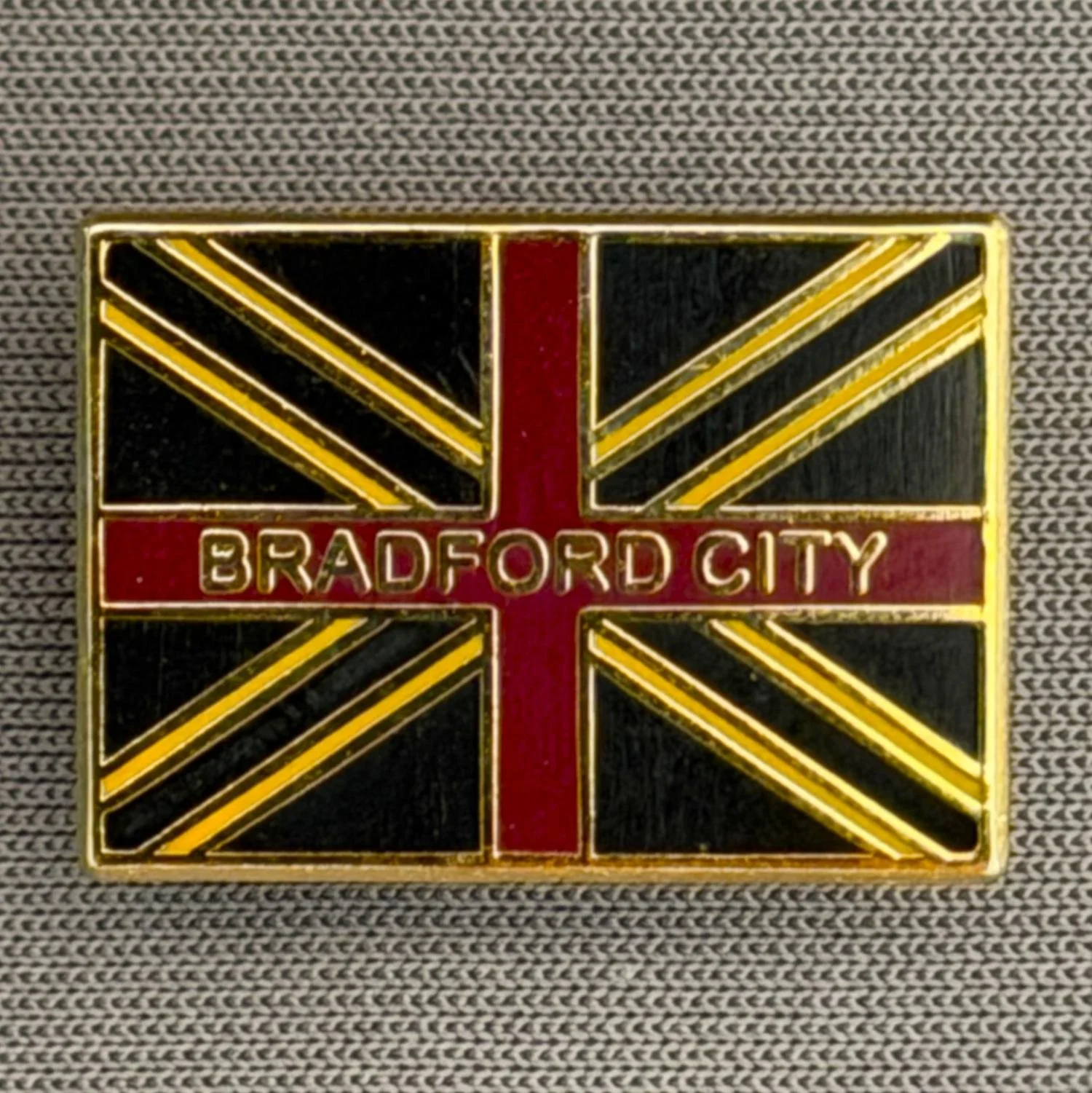 Reference Number: BCFLA031
Size: H 14.7 mm x W 20.5 mm
Pin Type: Brooch Pin
Plating: Antique Gold
Value: £6
Manufacturer: Not Known
Comments: Union Flag Bradford City
