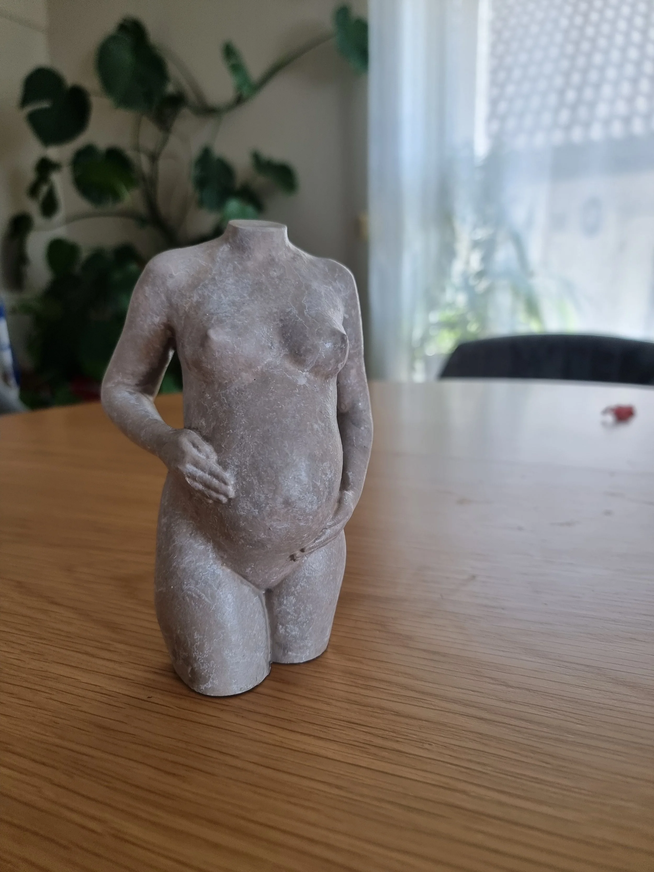 Gravidskulptur med Sculpts signaturutførelse i stein, der kroppens former og detaljer fremheves. Denne i varme toner