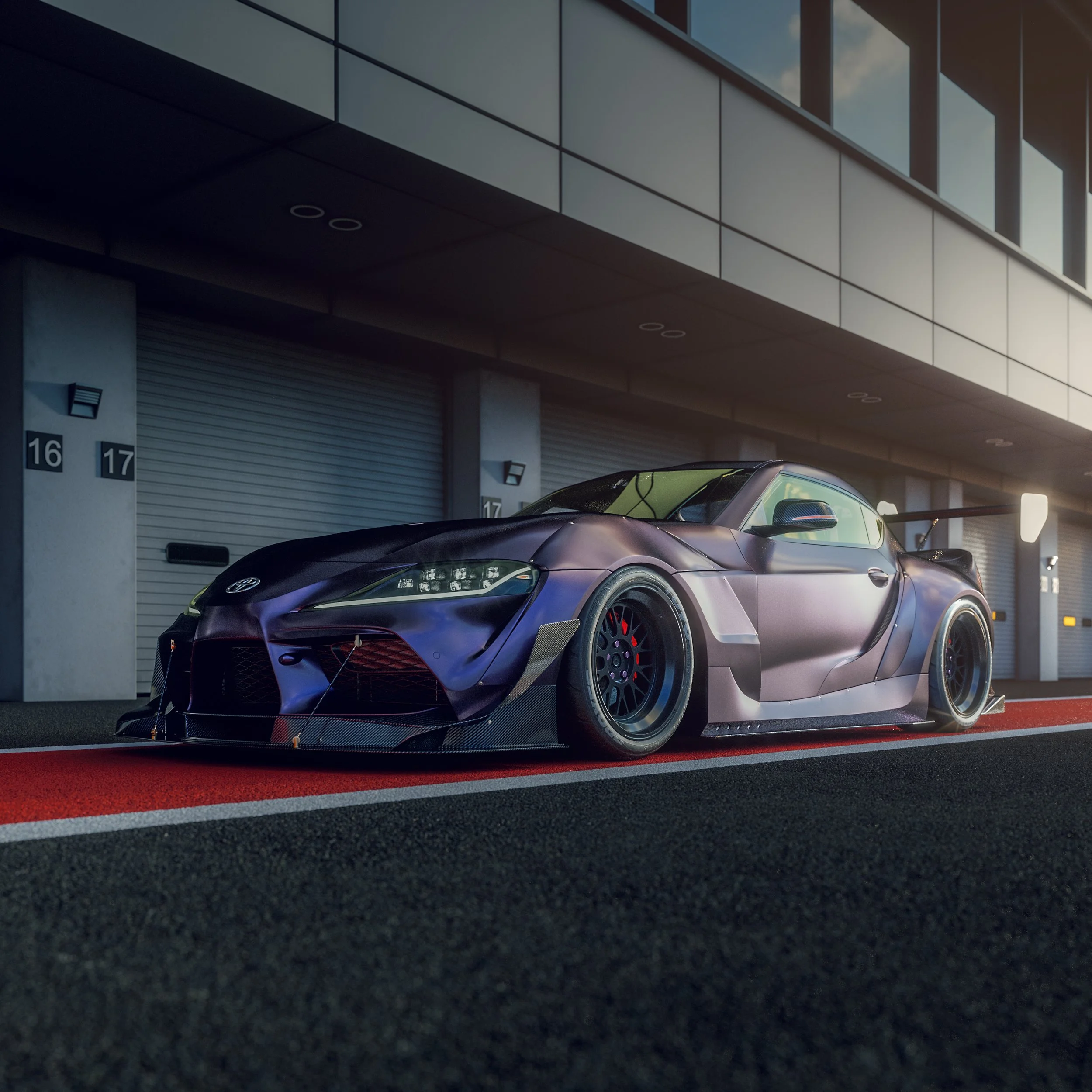 A sleek, black race car with aerodynamic design parked on a racing track near garage doors.