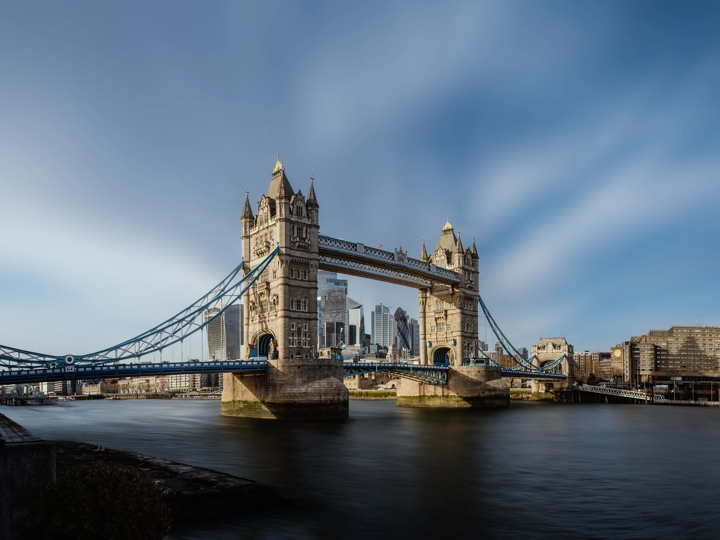 View of Tower Bridge in London with a clear sky and the city skyline in the background.