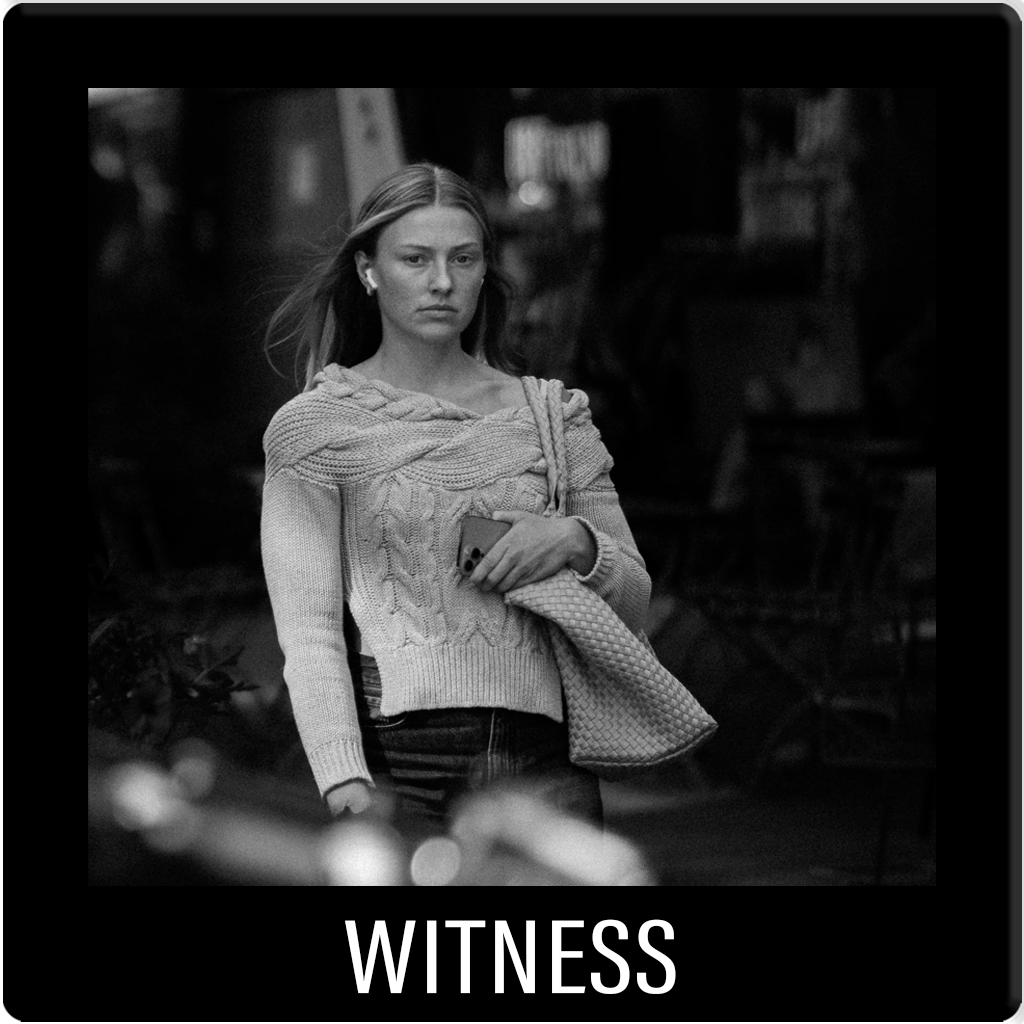 Candid black and white street photography. A fleeting human moment captured within the urban environment.