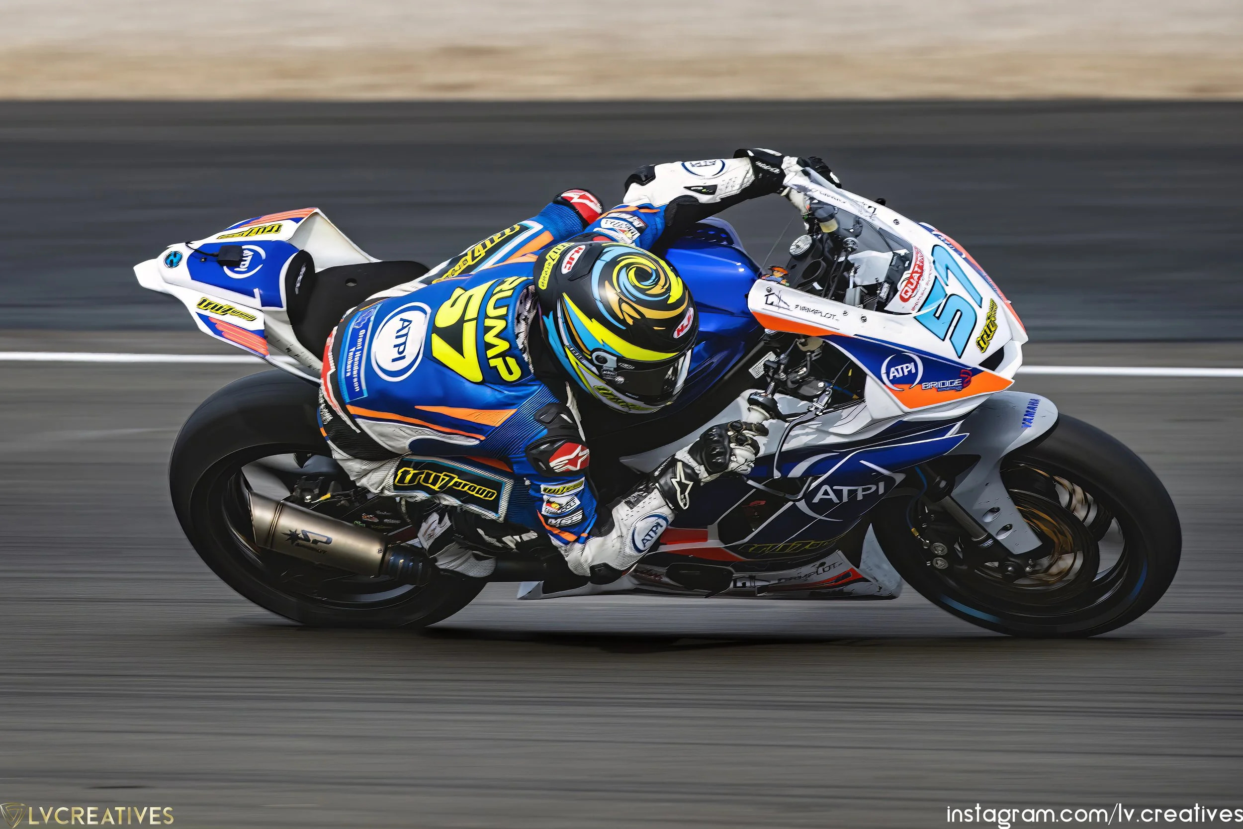 A motorcyclist racing on a track, leaning into a turn while riding a colored blue and white motorcycle with various sponsor logos.